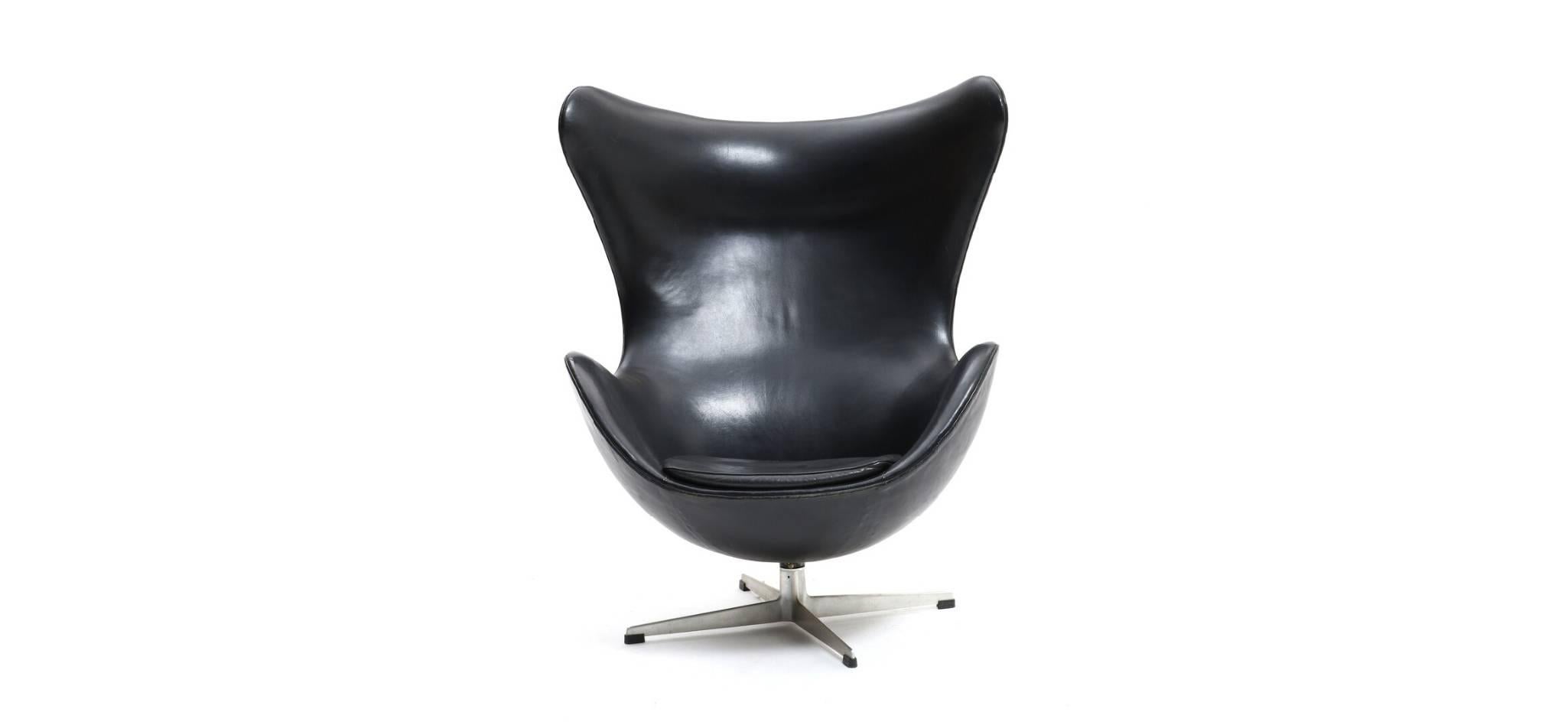 Arne Jacobsen: “The Egg Chair”. Manufactured by Fritz Hansen.
Easy chair with profiled aluminium base and stem, shell and loose cushion upholstered with black patinated leather. Model 3317. Designed 1958. Manufactured and marked with label by Fritz