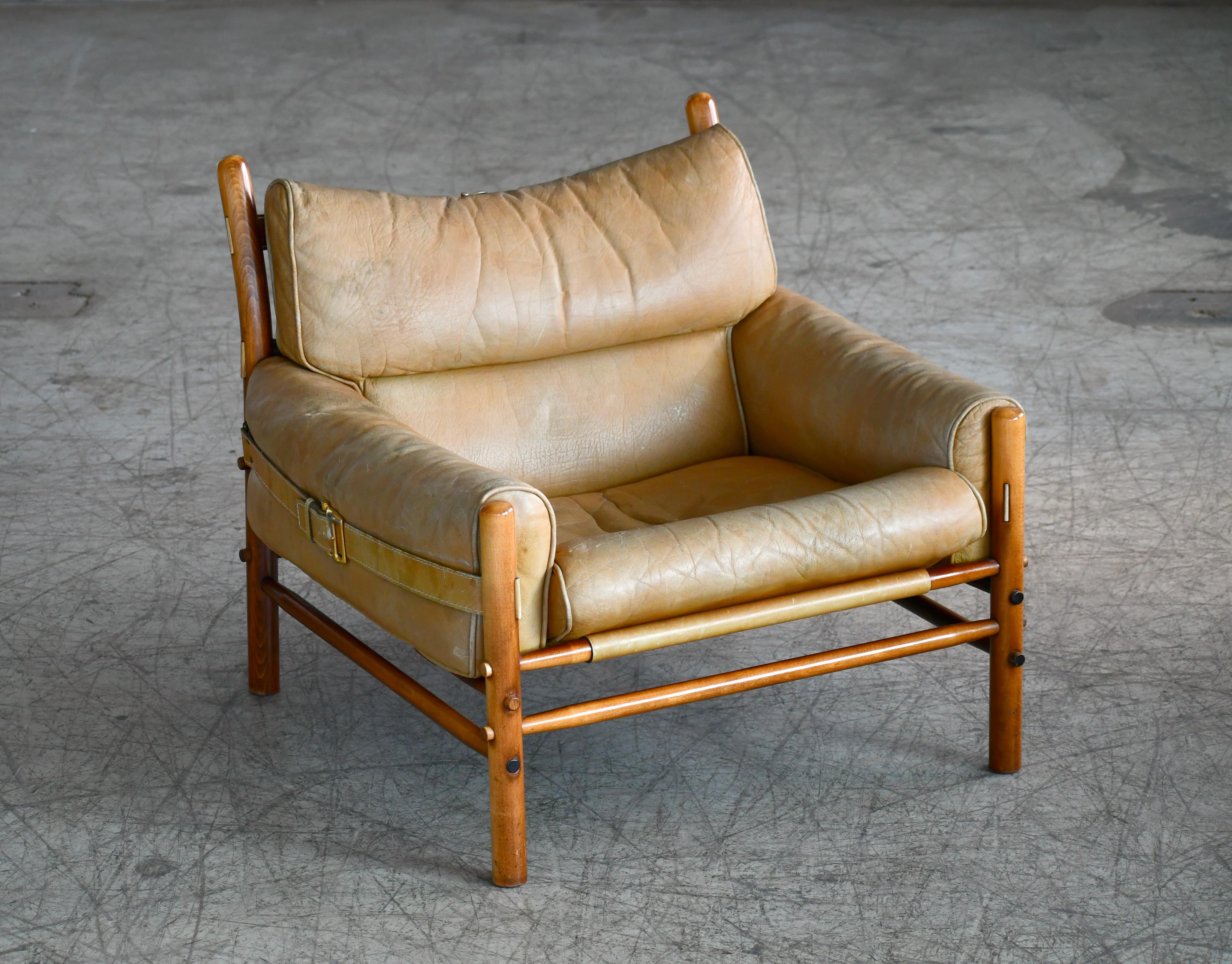 Beautiful 1960s model Inca low version safari chair in tan leather and beech wood designed by Arne Norell in the late 1960s for Norell Mobler, Sweden. The chair is assembled without any screws or hardware and held together by the heavy gauge saddle