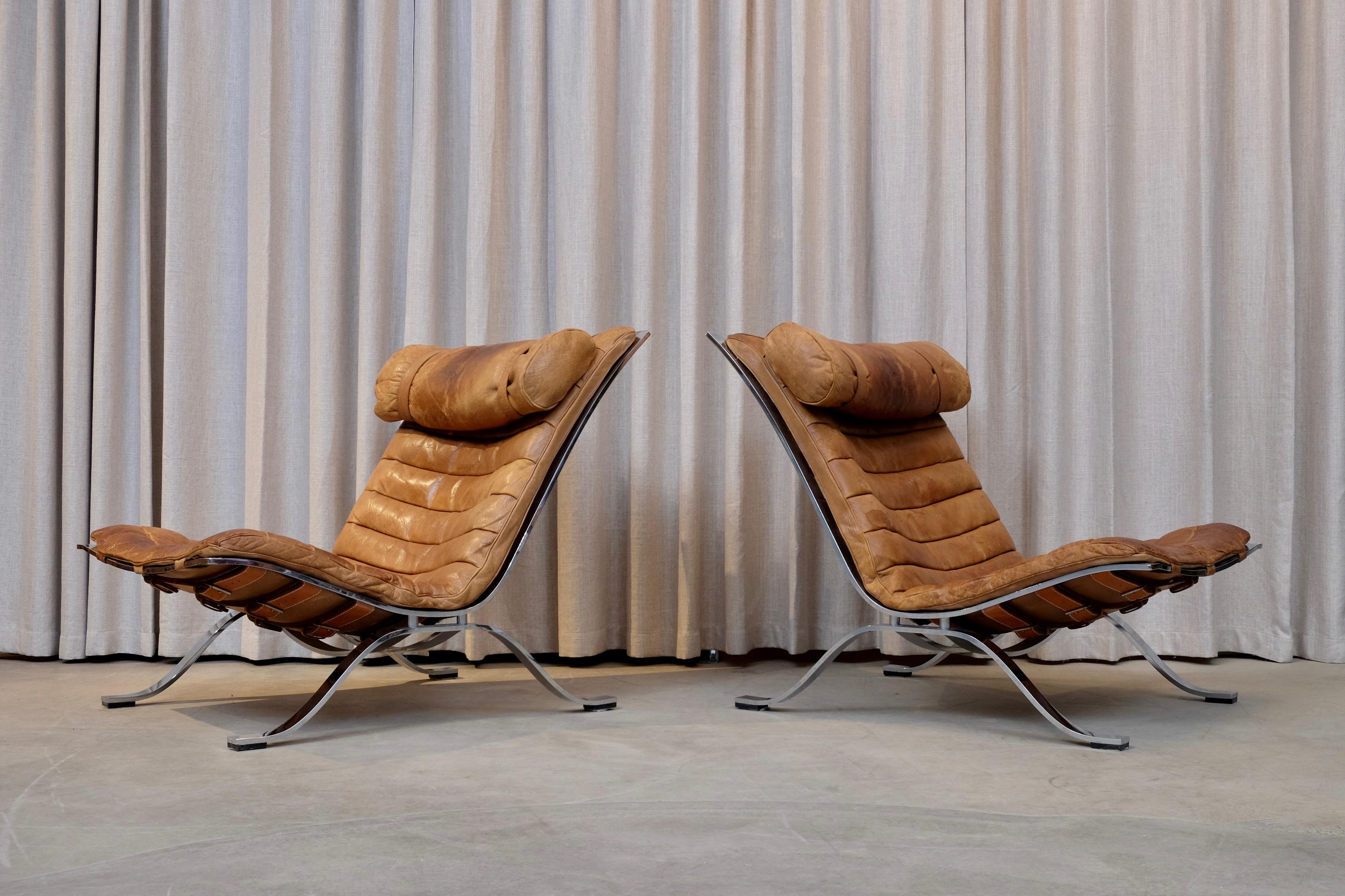 A great pair of Ari chairs designed in 1966, by Arne Norell. Produced by Arne Norell AB in Aneby, Sweden, 1960s. Excellent original condition with signs of usage and patina.