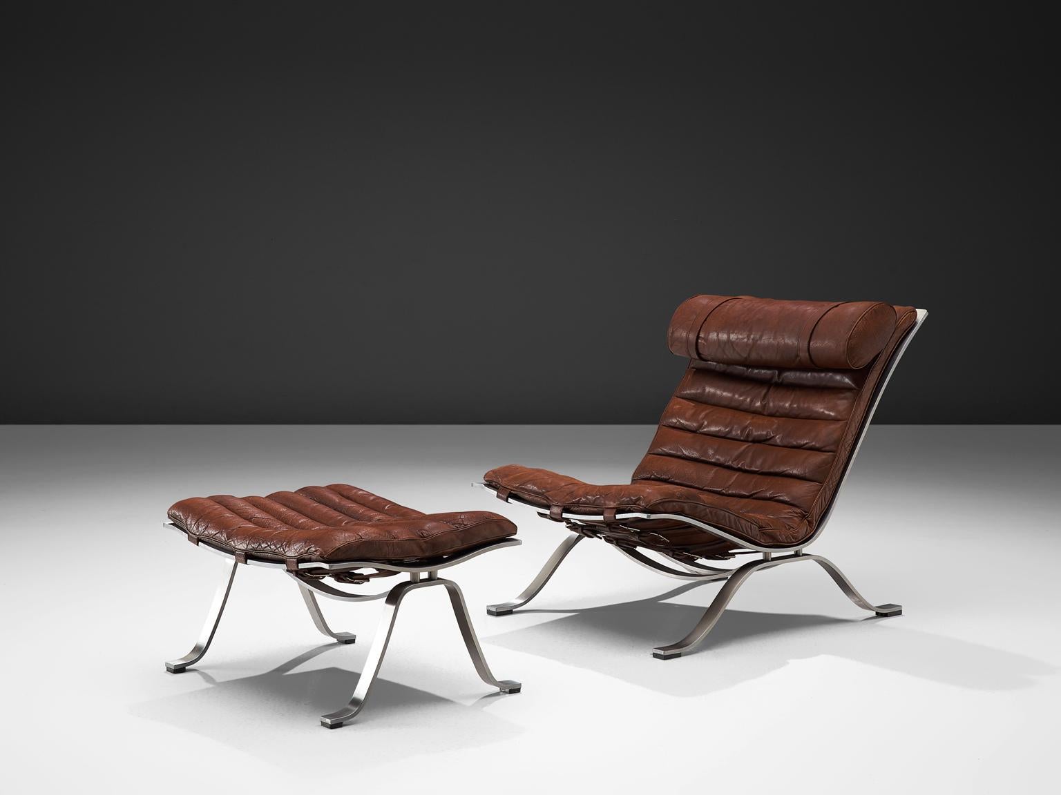 Arne Norell for Norell Møbel AB, 'Ari' lounge chair and ottoman, brown leather, chrome-plated steel, Denmark, 1966

This lounge chair is designed by Arne Norell. This chair, model Ari, comes with a footstool. The whole frame is executed in