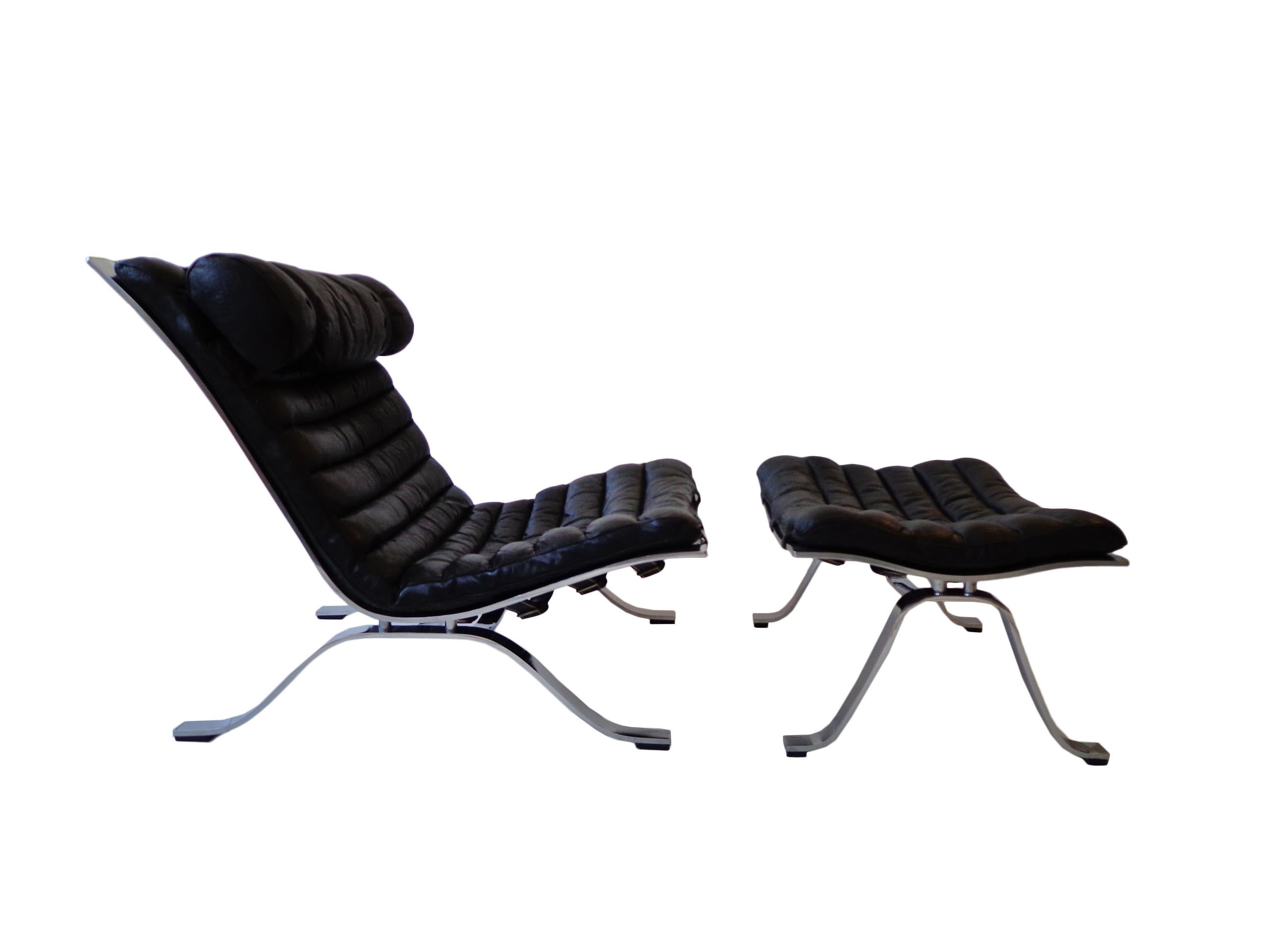 Comfortable lounge chair and ottoman designed by Arne Norell. This award winning lounge chair in 1973 is made of high quality matt polished steel and original black leather. The set is in nice vintage condition with fantastic patina from age and