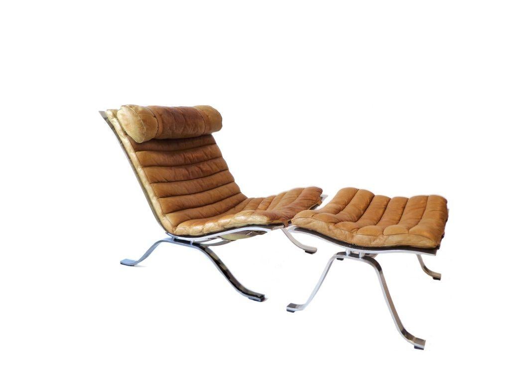 Comfortable lounge chair and ottoman designed by Arne Norell. This award winning lounge chair is made of high quality flat matt-chrome plated steel and original brown leather. The set is in beautiful condition with fantastic patina from age and