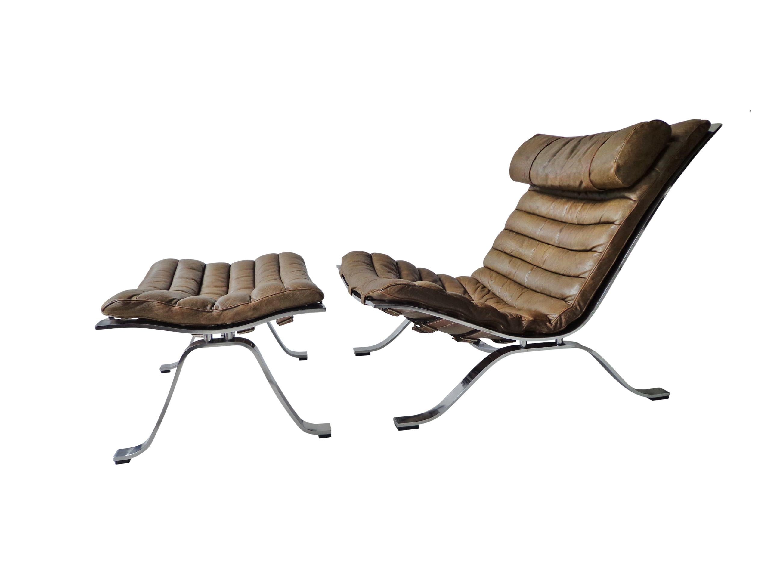 Comfortable lounge chair and ottoman designed by Arne Norell. This award winning lounge chair is made of high quality flat matte-chrome-plated steel and original cognac/brown leather. The set is in beautiful condition with fantastic patina from age