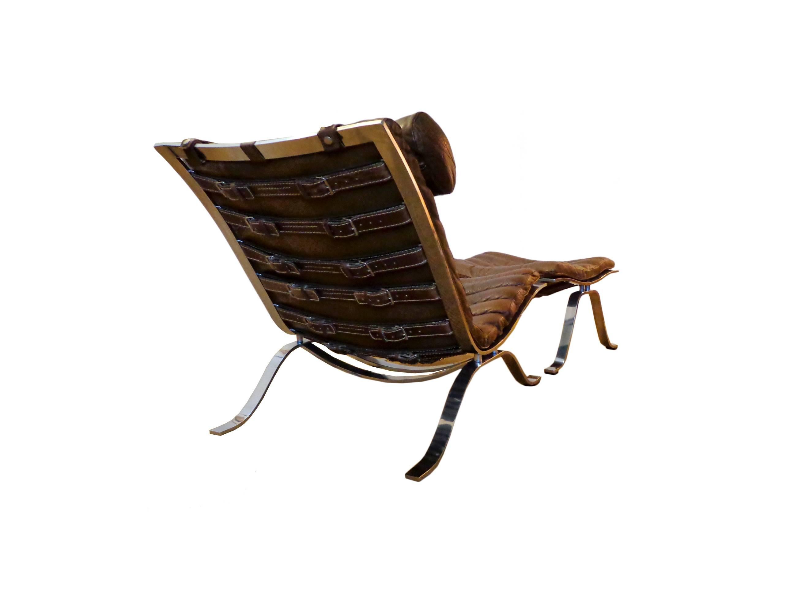 Offerd by Zitzo, Amsterdam: Comfortable lounge chair with ottoman designed by Arne Norell. This award winning lounge chair was made of high quality flat chrome-plated steel and has very thick original cognac/brown buffalo leather. The set is in