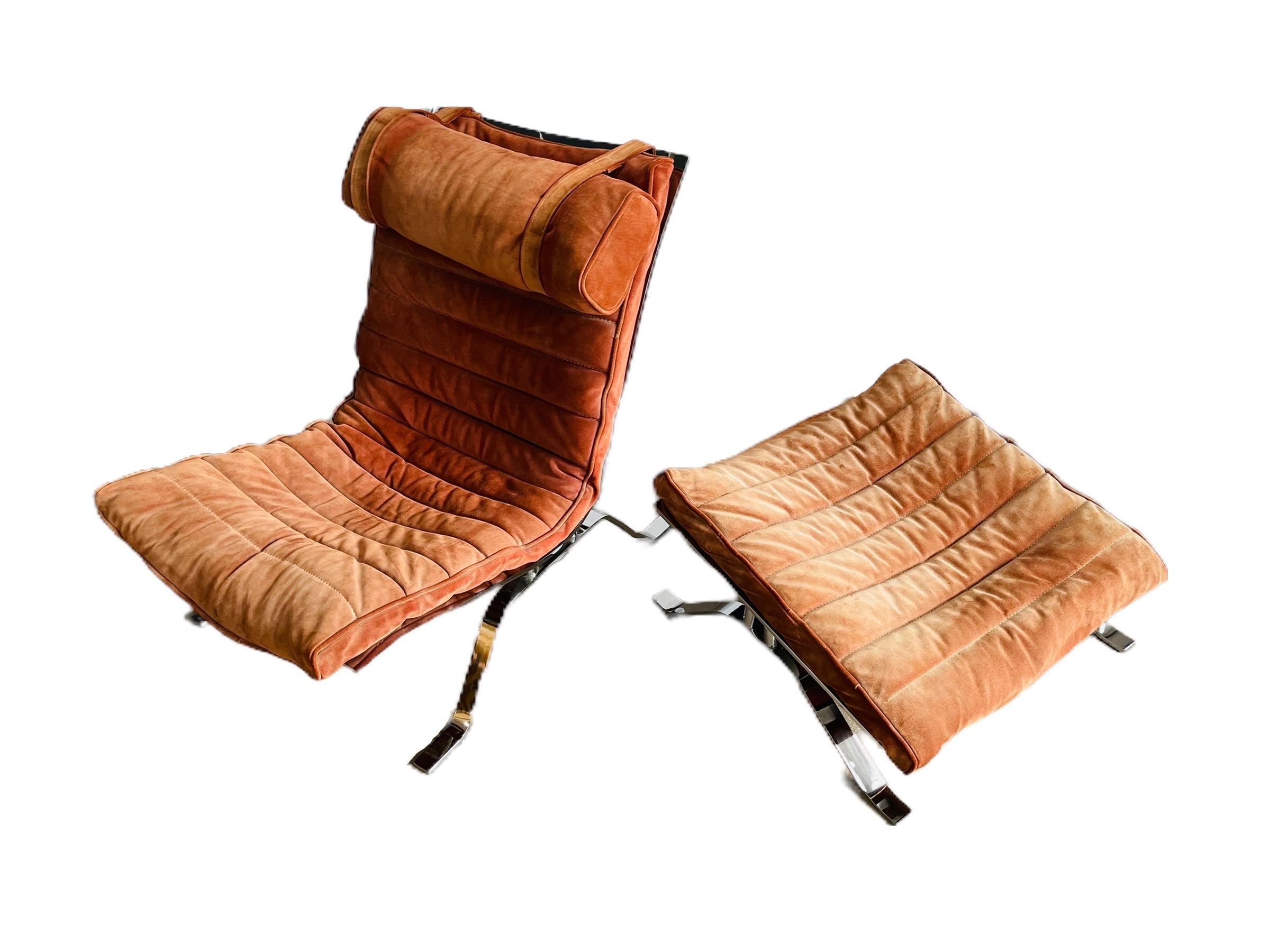 “ARI” lounge chair and ottoman by Swedish designer Arne Norell circa 1950s. This chair has original suede upholstery with brown leather straps on chrome frame. The chair is in good vintage condition with normal wear consistent with age and use.