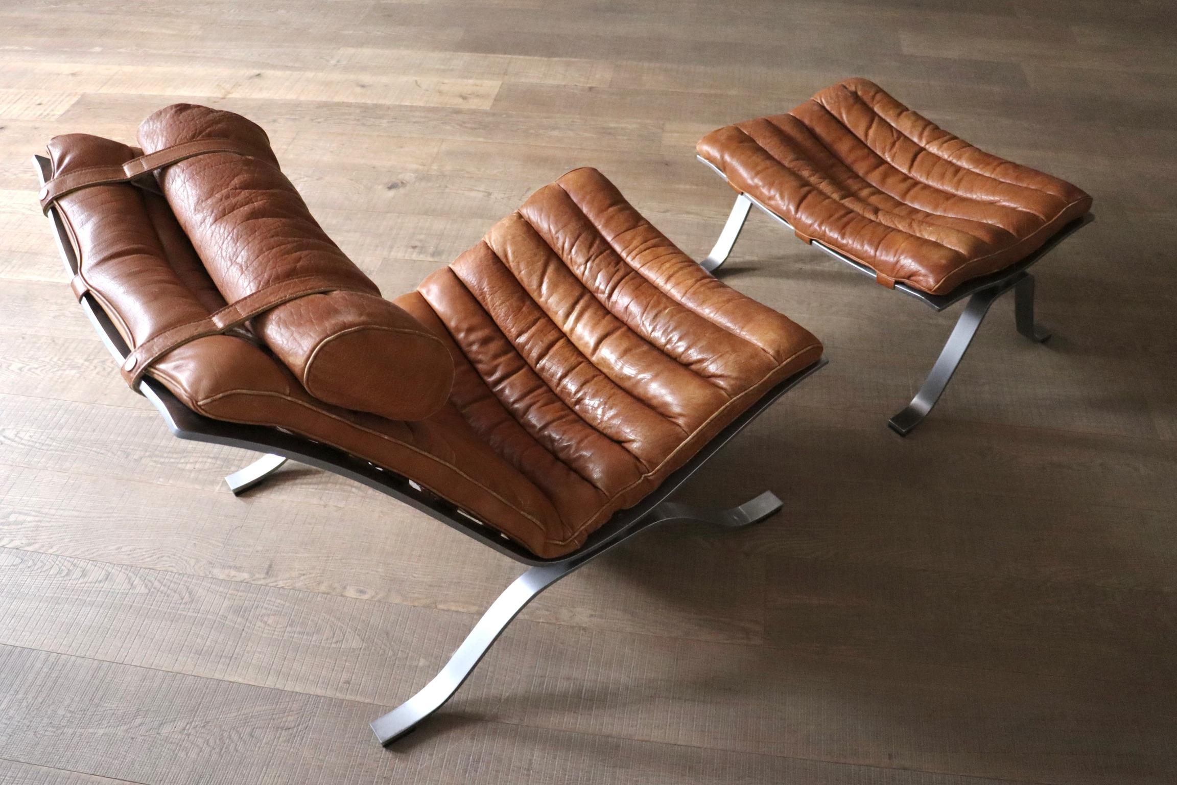 Stunning Ari lounge chair with ottoman in cognac leather, designed by Arne Norell, and manufactured by Norell Mobler AB, Sweden 1966.

The structure is made of solid steel, which is curved in an elegant way. The seating is attached to the frame with