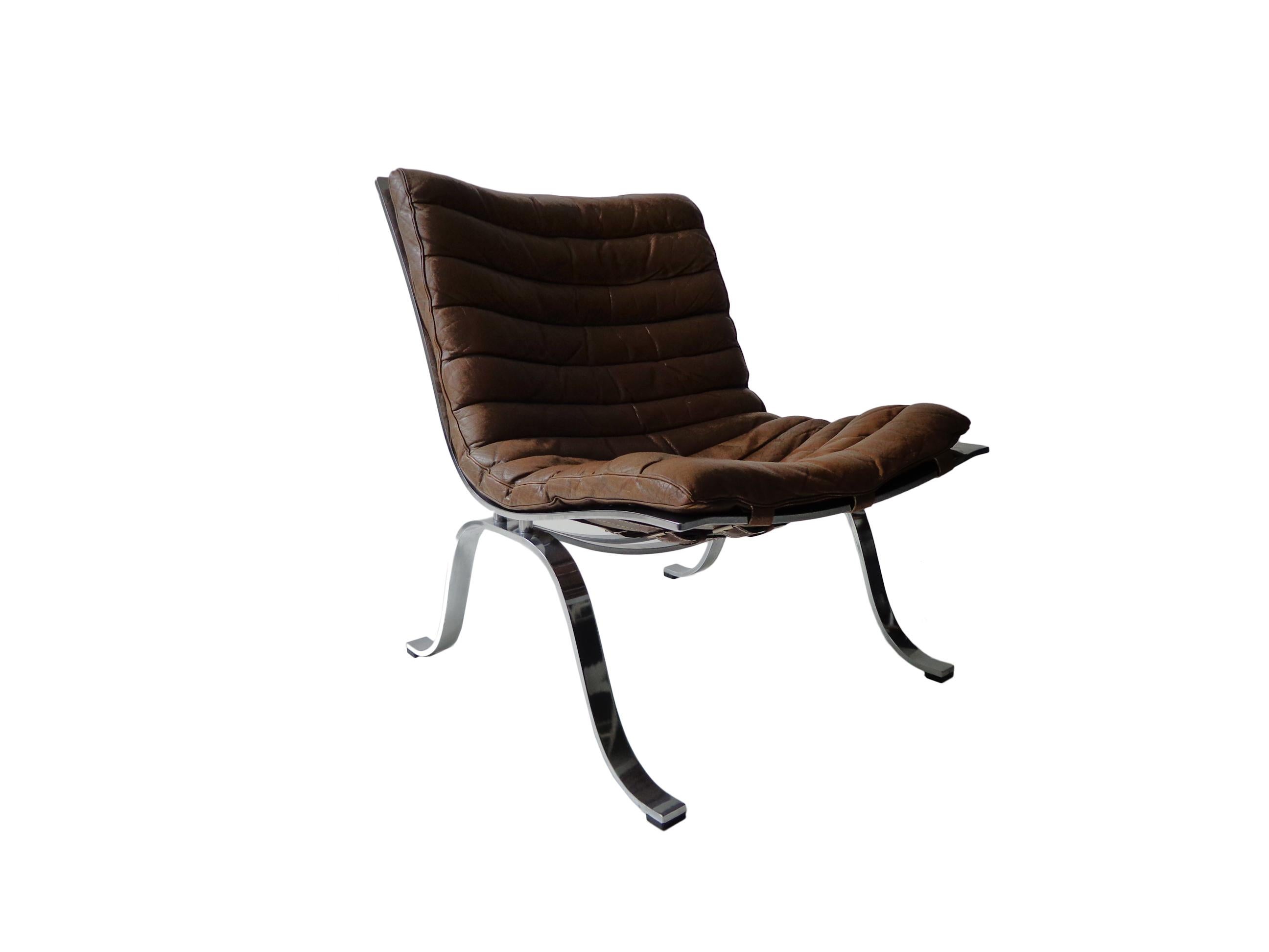 Comfortable 'Ariet' easy-lounge chair and ottoman designed by Arne Norell. This chair is made of high quality flat matt, chrome-plated steel and original cognac/brown leather. The chair is in beautiful condition with fantastic patina from age and