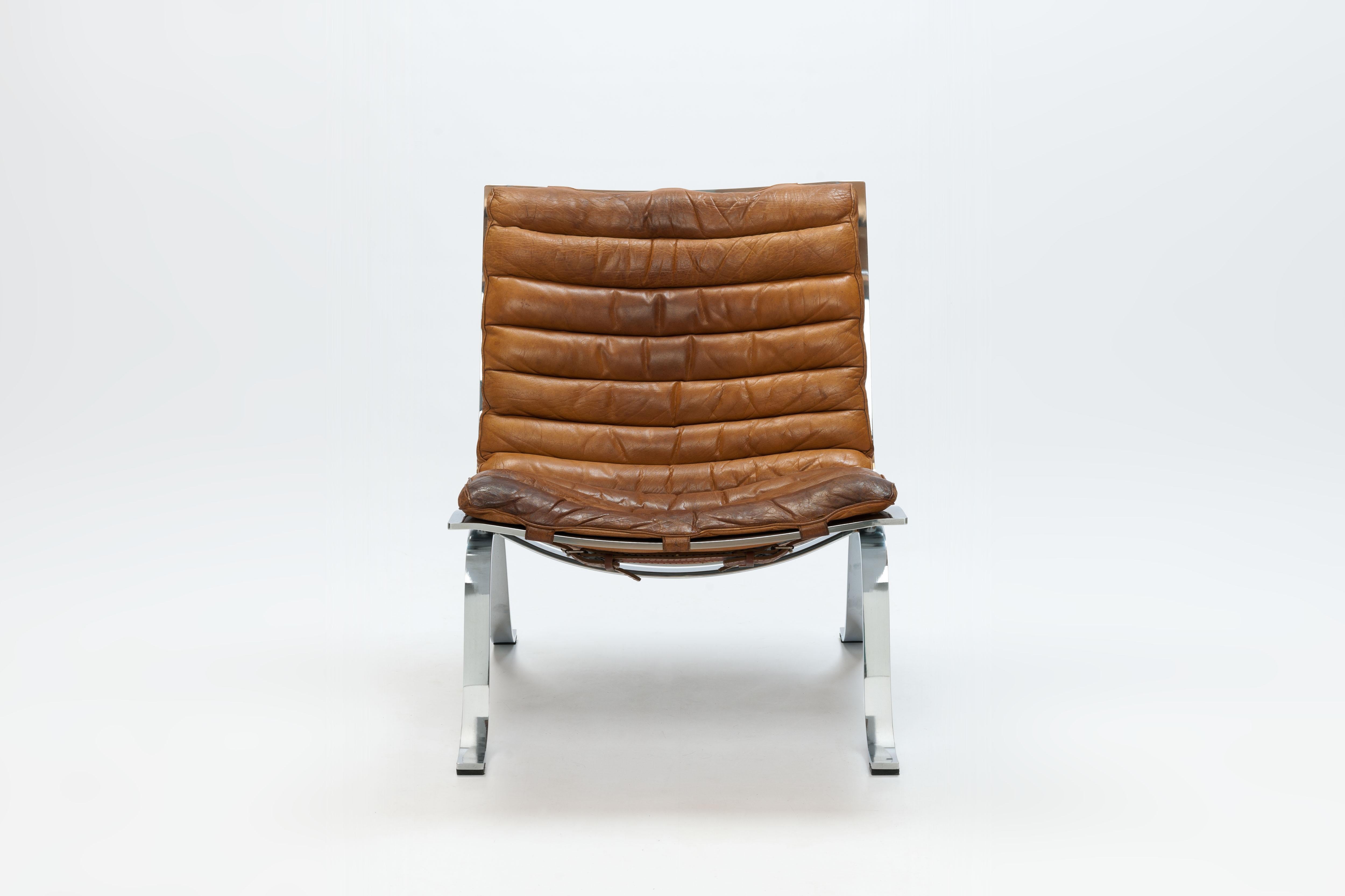 Rarely seen 'Ariet' lounge chair by Swedish Designer Arne Norell in a beautiful brown patinated buffalo leather and finest high gloss chromed frame. 
Please note the beautiful belts with buckles, this distinct detailing gives the chair a beautiful