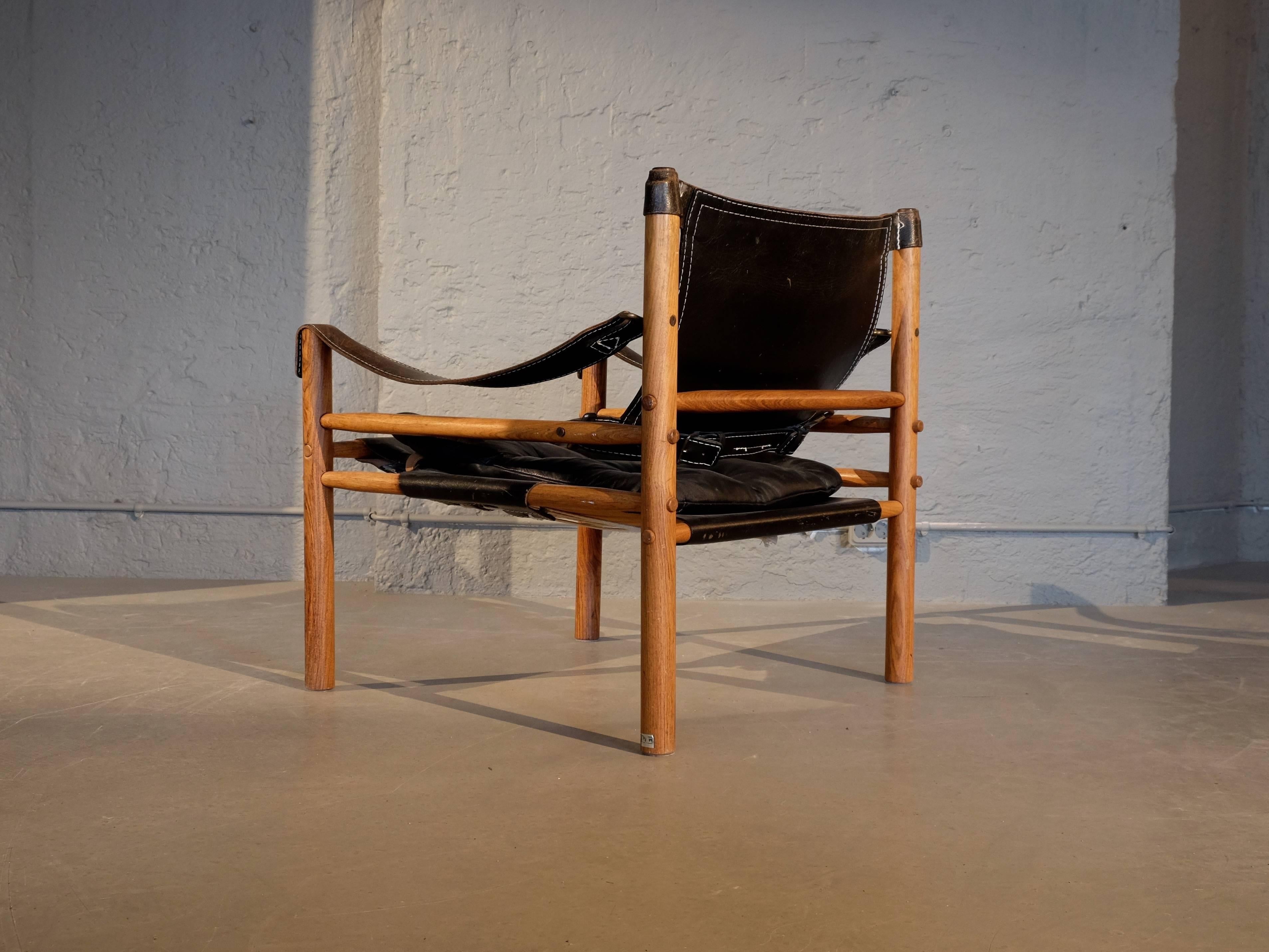 Lovely safari chair or easy chair in black leather and rosewood designed by Arne Norell, 1964, produced by Arne Norell AB in Aneby, Sweden, 1960s.
 