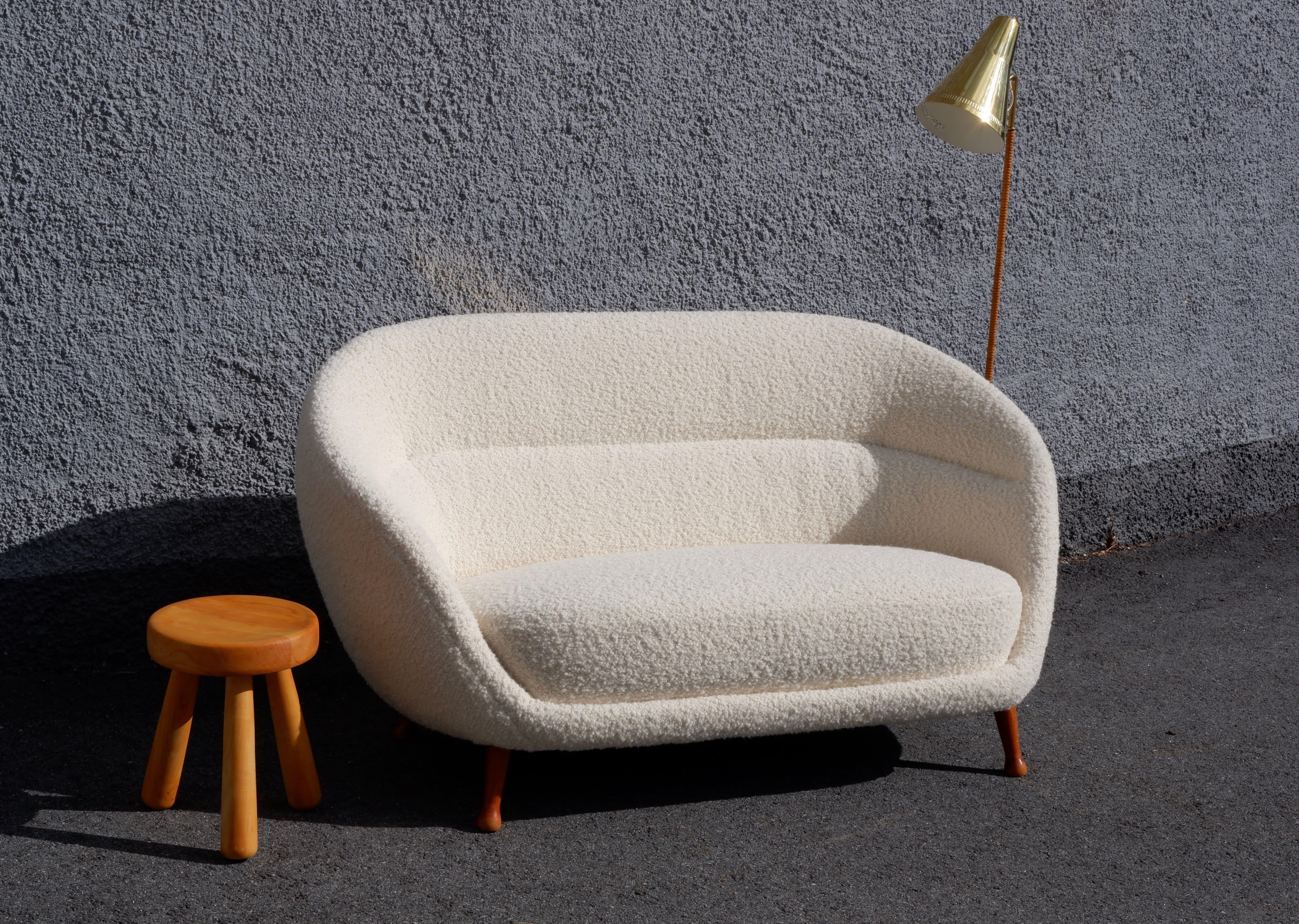 Ein seltener kurvenreicher 3-sitziger Arne Norell Soffa, hergestellt von Westbergs Möbler Edition im Jahr 1950. Das Sofa besteht aus gebeizten Buchenfüßen und ist mit einem Bouclette-Stoff in Weiß neu bezogen. Das Sofa befindet sich in einem