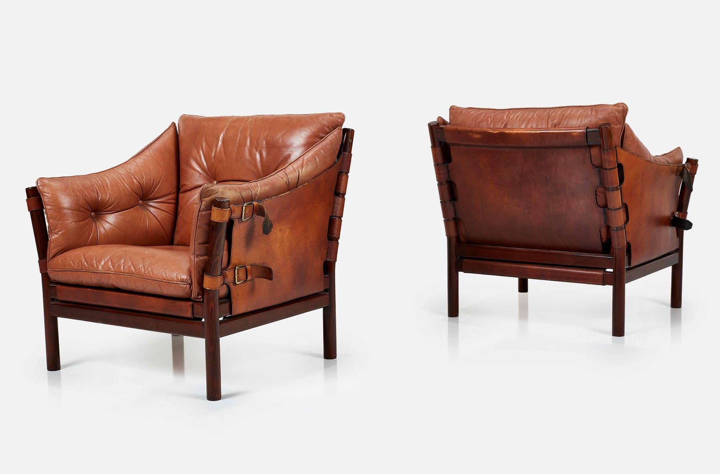 Pair of stunning leather and rosewood 'Ilona' lounge chairs by Arne Norell, circa 1971.

Leather, rosewood, fabric, brass. Manufactured by Norrel Mobel AB, Sweden.

Classic Arne Norell design features a very clever construction which creates a