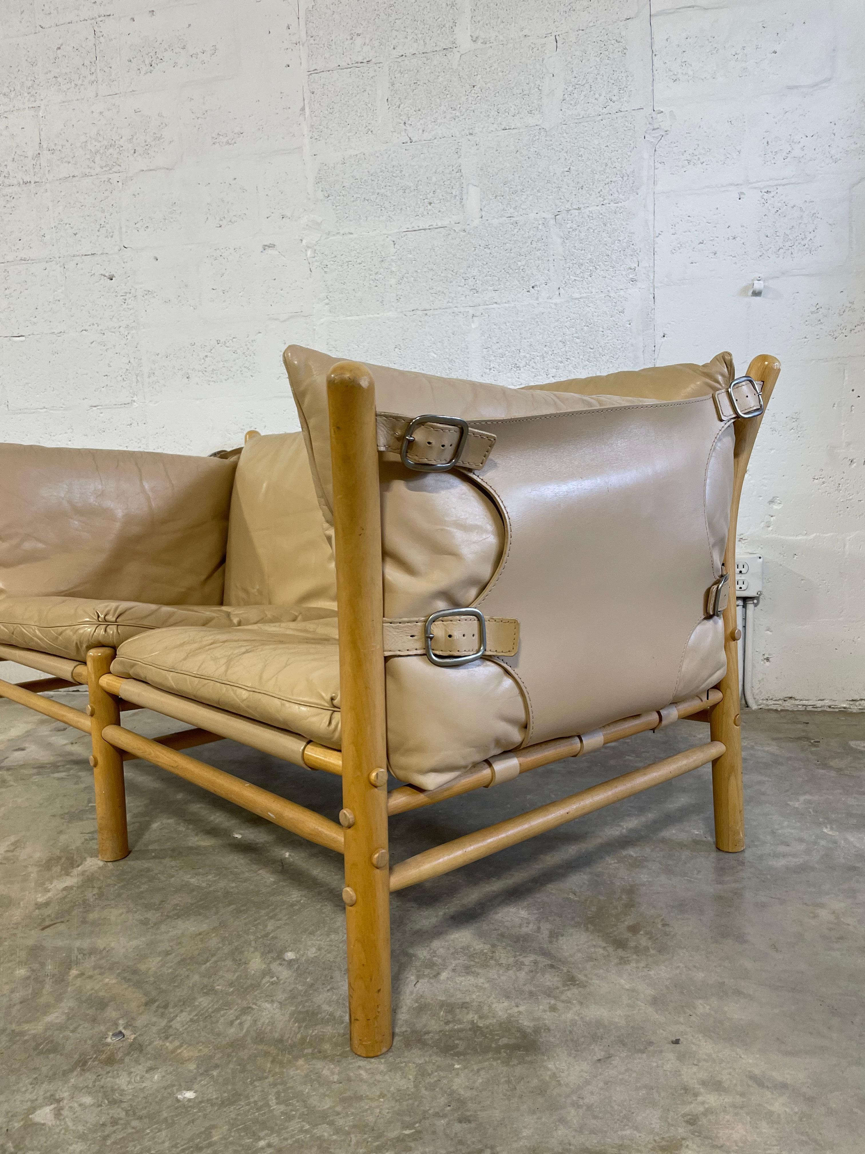 Arne Norell Ilona Safari Loveseat or Two-person Sofa. Made in Sweden. Original leather cushions. Hard to find color. Patina on leather. Labeled. Leather sling on sides and back, loose cushions. Manufactured by Aneby Møbler. 
