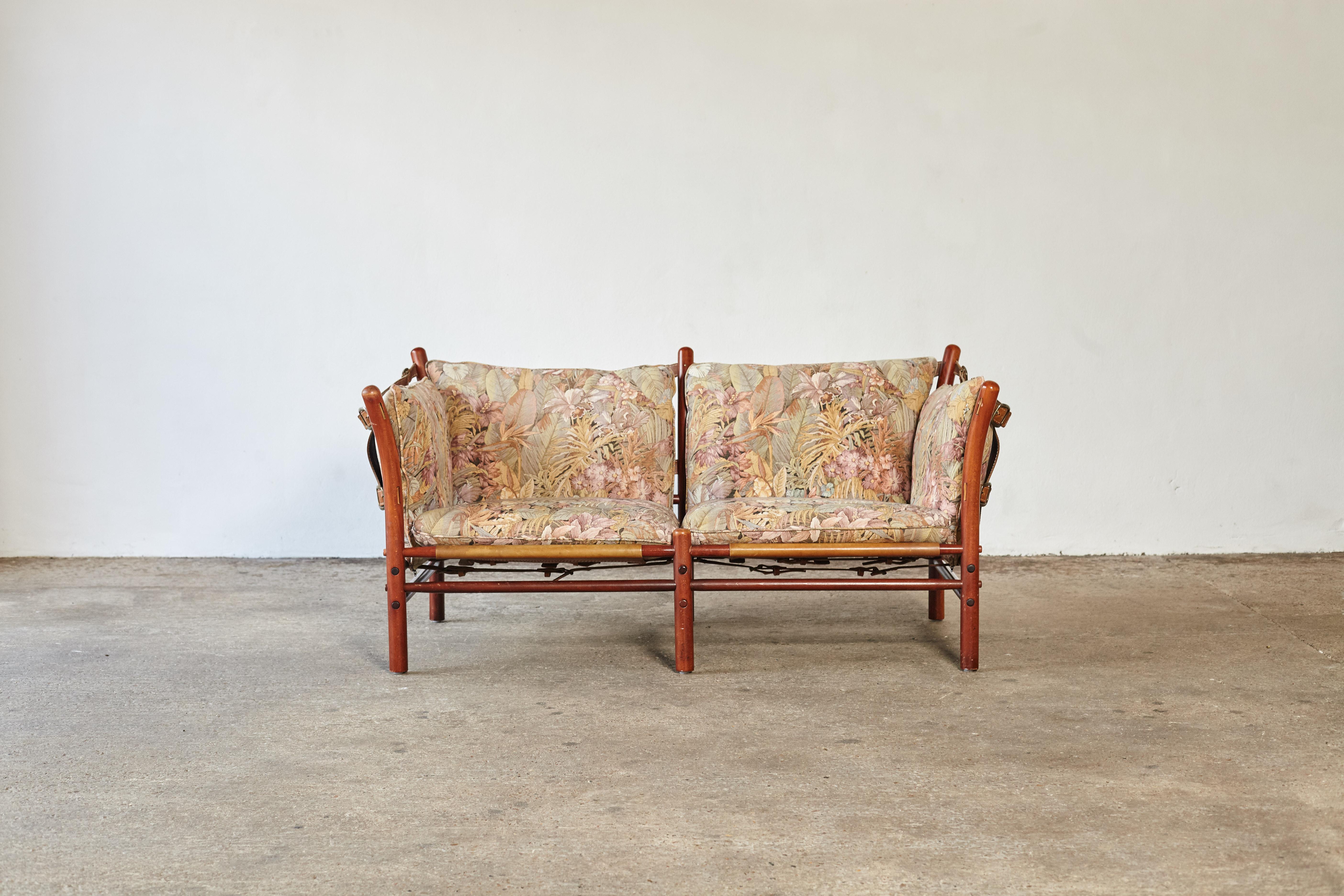 An original two-seat Arne Norell Ilona sofa with cushions in original floral fabric. Made by Norell Mobler in Sweden. In good vintage condition with minor signs of use and wear relative to age. The cushions are loose and easy to recover if desired.