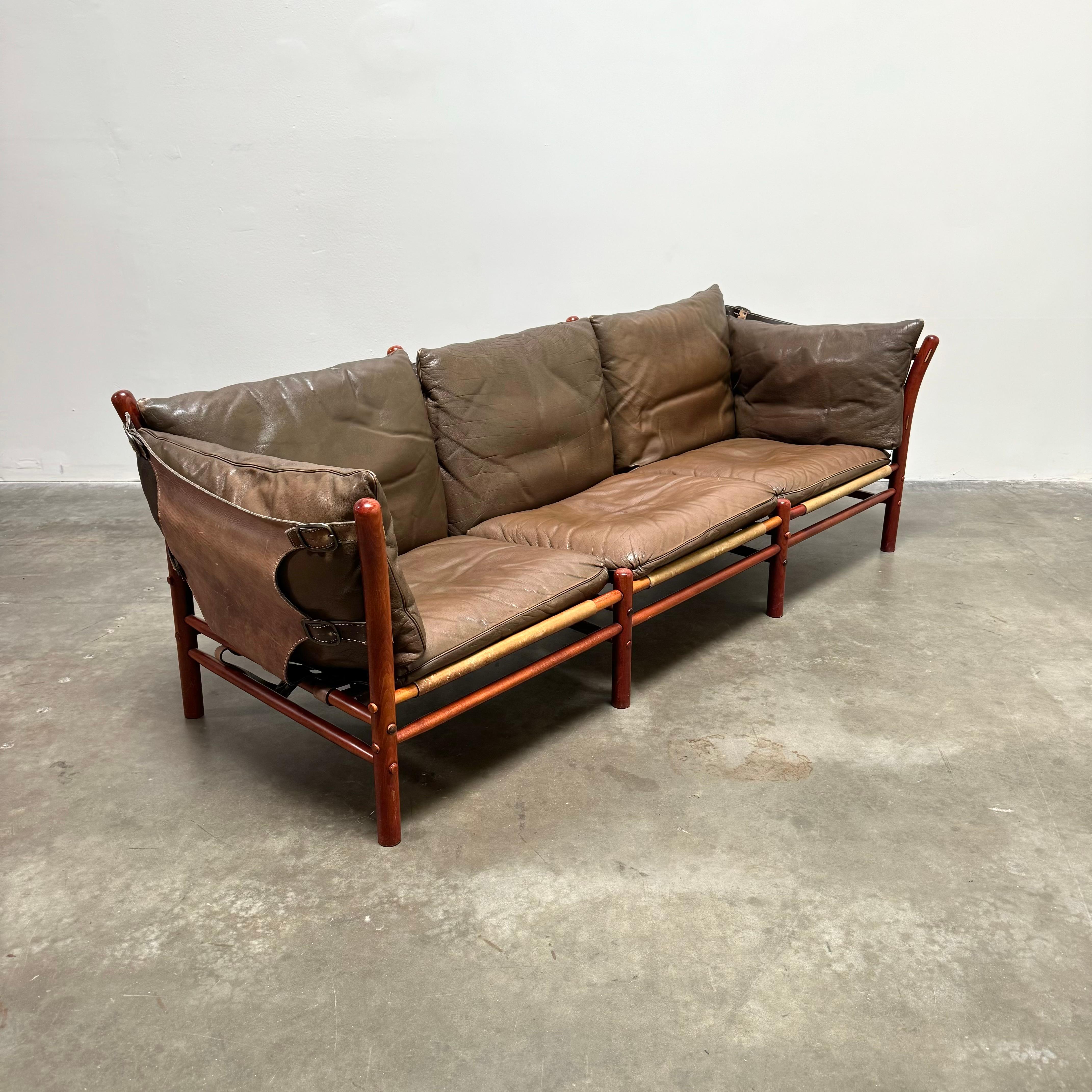 Beautiful Swedish three-seater sling sofa designed by Swedish designer Arne Norell in 1971. 

Entirely handmade, the wooden frame is made from stained beech and the original leather cushions are in excellent condition featuring a beautiful patina.