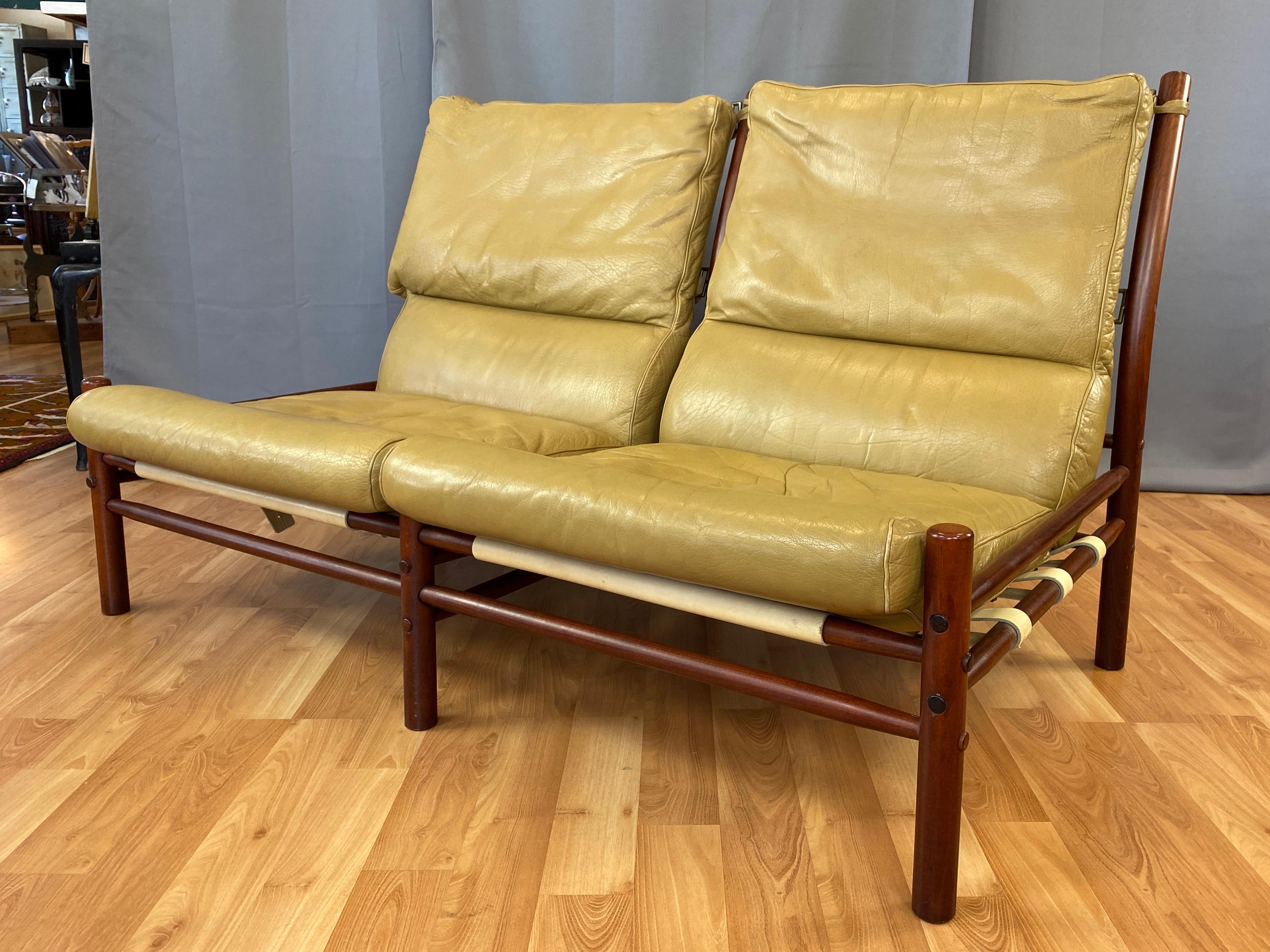 A handsome 1970s Inca armless settee or two-seat sofa by Swedish designer Arne Norell in teak-colored beech and light tan leather.

Solid beech frame with a tinted finish that gives it an attractive teak-like appearance. Tapered dowel crosspiece