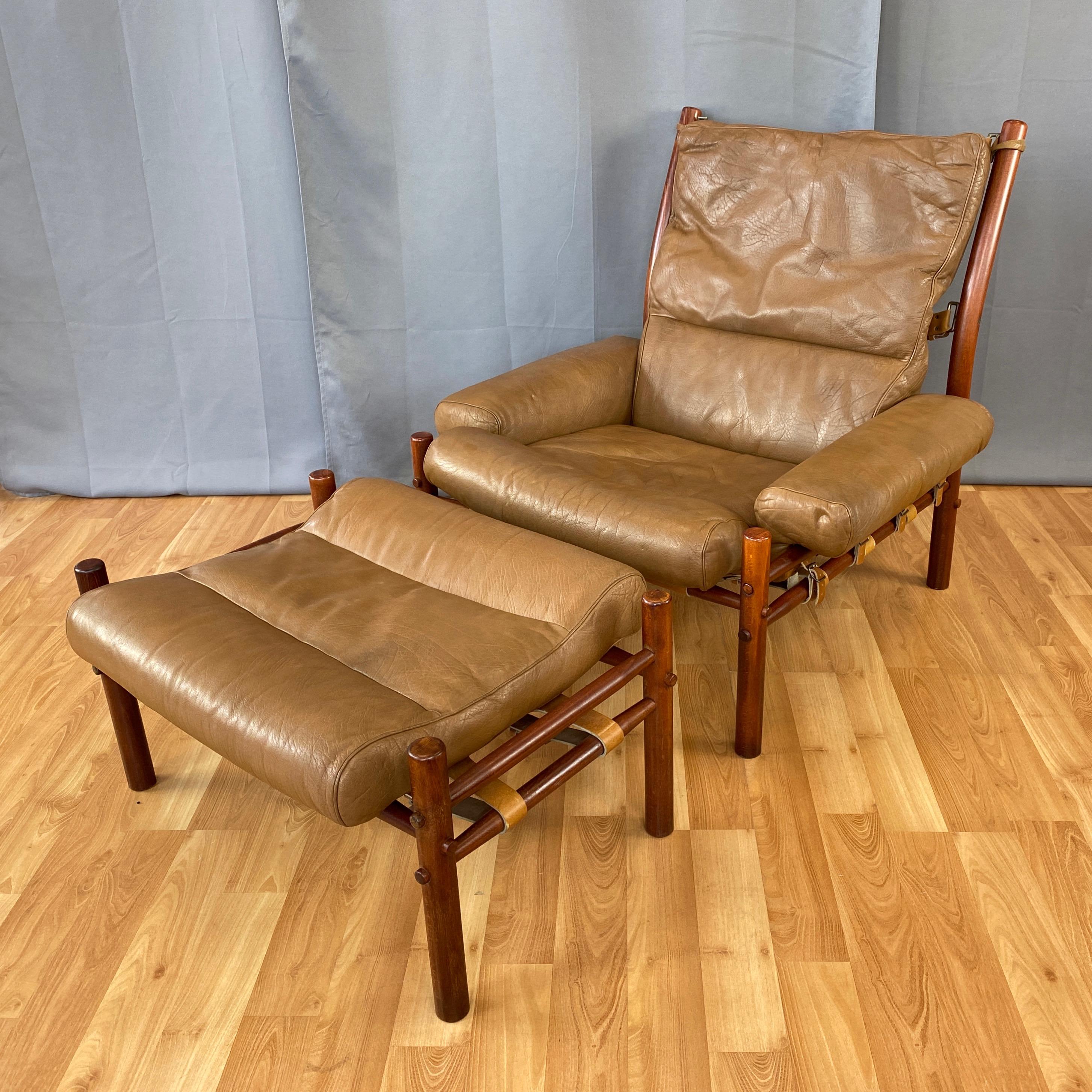 A very handsome 1970s Inca lounge chair & ottoman by Swedish designer Arne Norell in teak-colored beech and dark tan leather.

Solid beech frames with a tinted finish that gives them an attractive teak-like appearance. Tapered dowel crosspiece