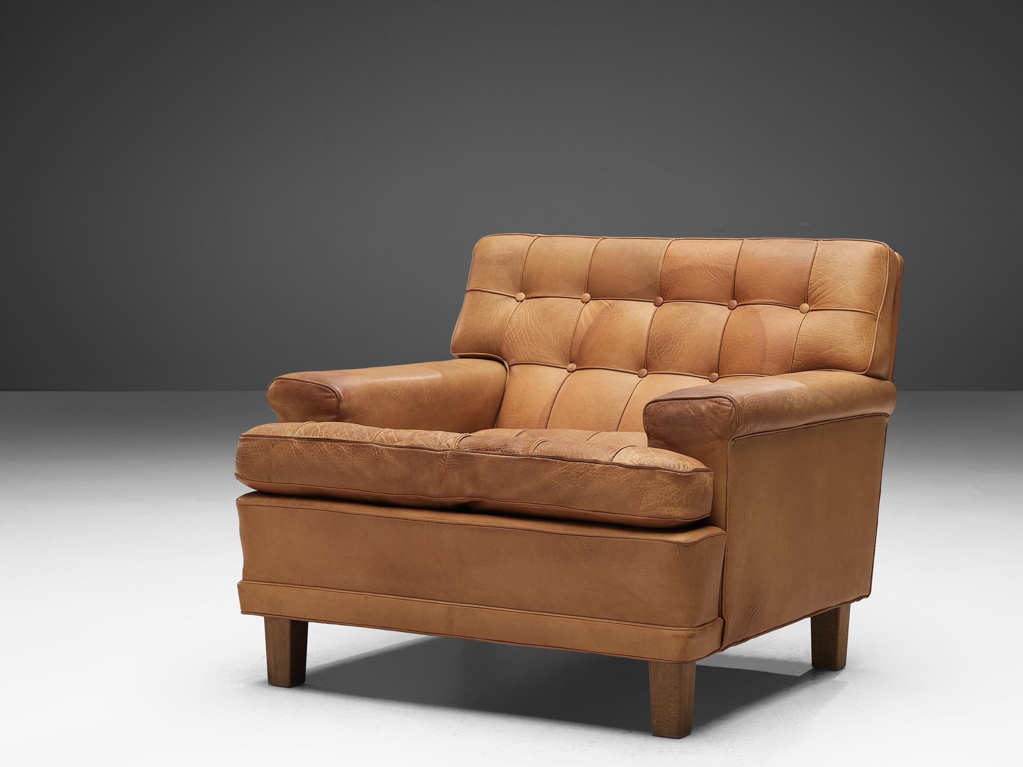 Arne Norell, lounge chair, in leather and wood, Sweden, 1960s.

Lounge chair designed by Arne Norell with wonderful shapes and comfort in cognac leather. The tufted leather cushions give these chairs an interesting appearance. The original buffalo