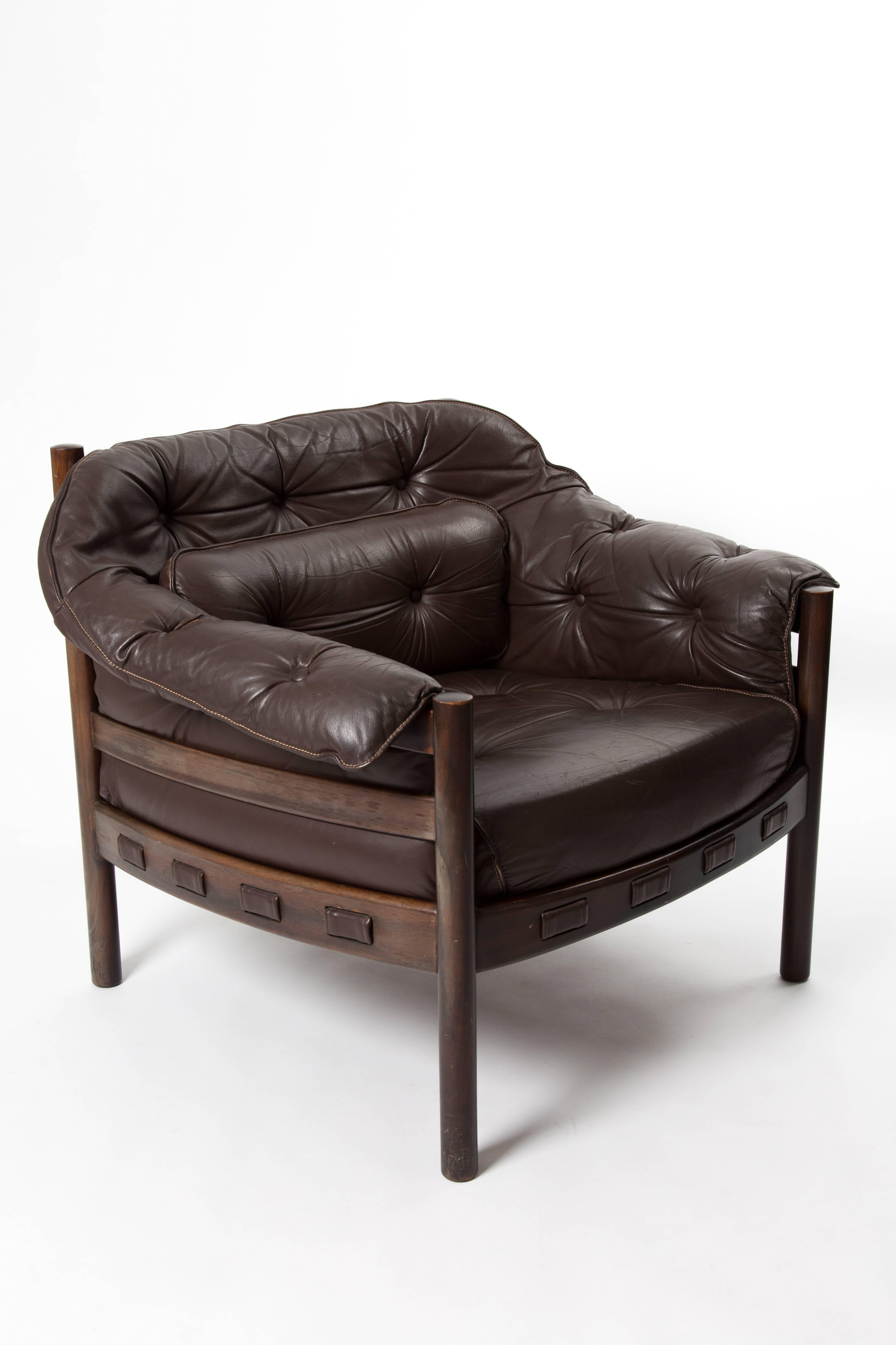 Arne Norell lounge chair. Teak wood frame. Brown leather with padded cushions.