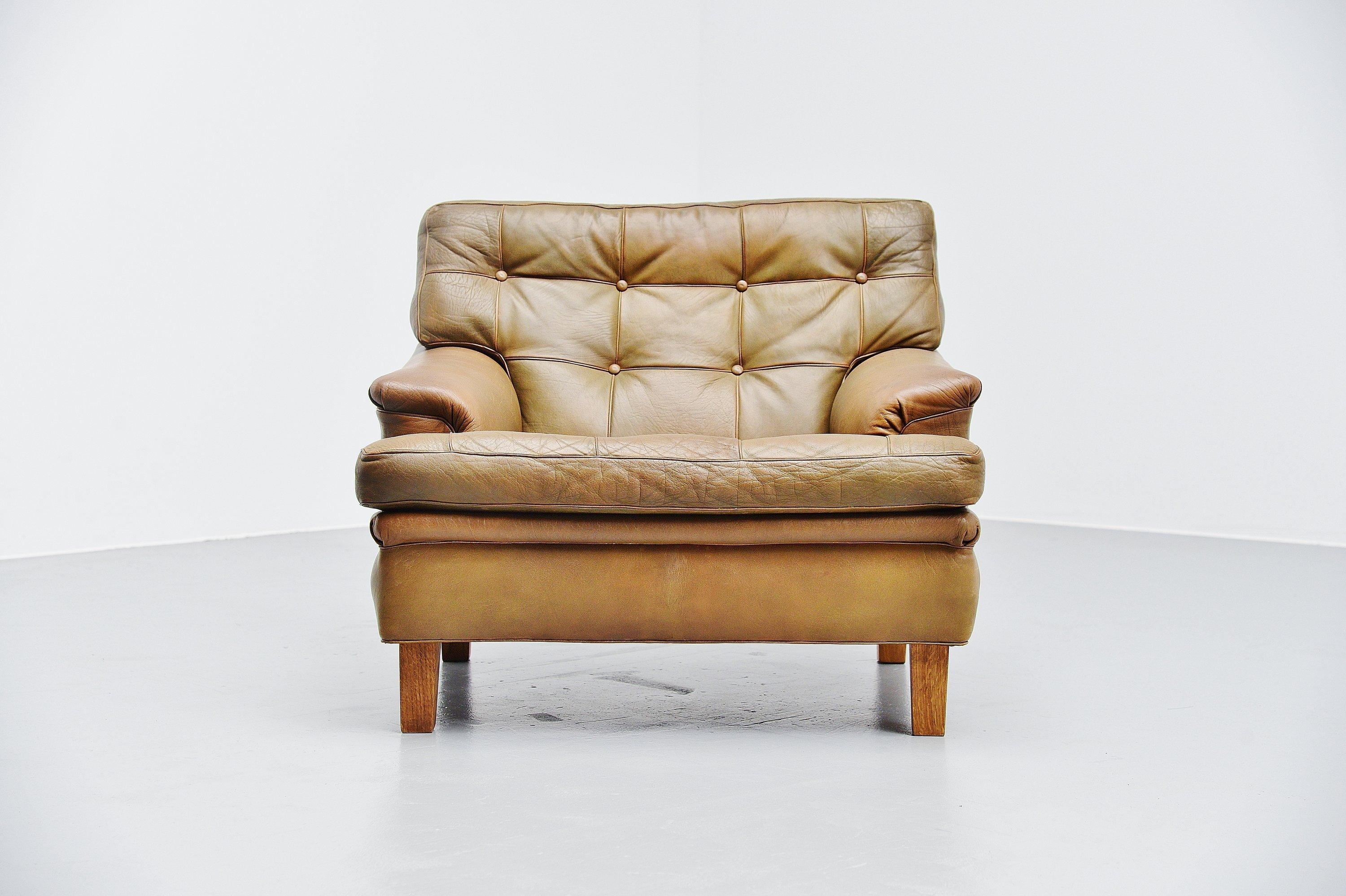 Très belle et confortable chaise longue Merkur conçue par Arne Norell et fabriquée par Arne Norell AB à Aneby, Suède, 1960. La chaise a de très beaux coussins en cuir touffeté vert olive avec des pieds en chêne massif. Le fauteuil est très