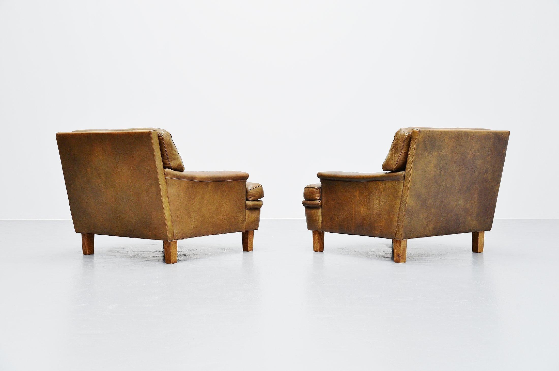 Very nice pair of Merkur lounge chairs designed by Arne Norell and manufactured by Arne Norell AB in Aneby, Sweden, 1960. The chairs have very nice olive green tufted leather cushions with solid oak feet. The chairs seat very comfortable, its a