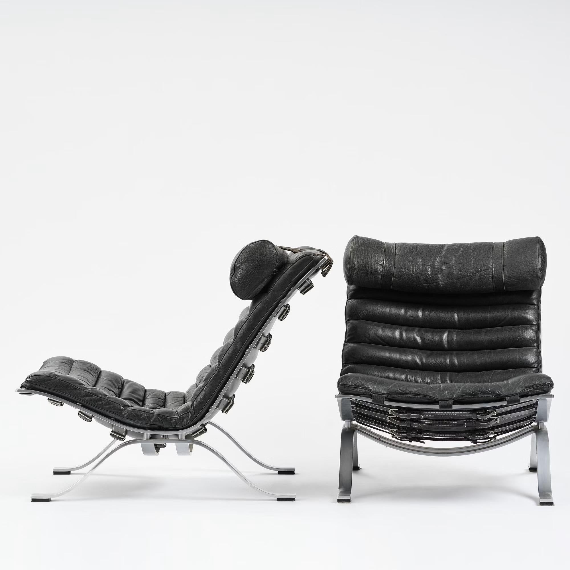 Paire de chaises de salon confortables conçues par Arne Norells. Cette chaise longue primée est fabriquée en acier poli mat de haute qualité et en cuir noir d'origine. L'ensemble est en bon état, avec une patine fantastique due à l'âge et à