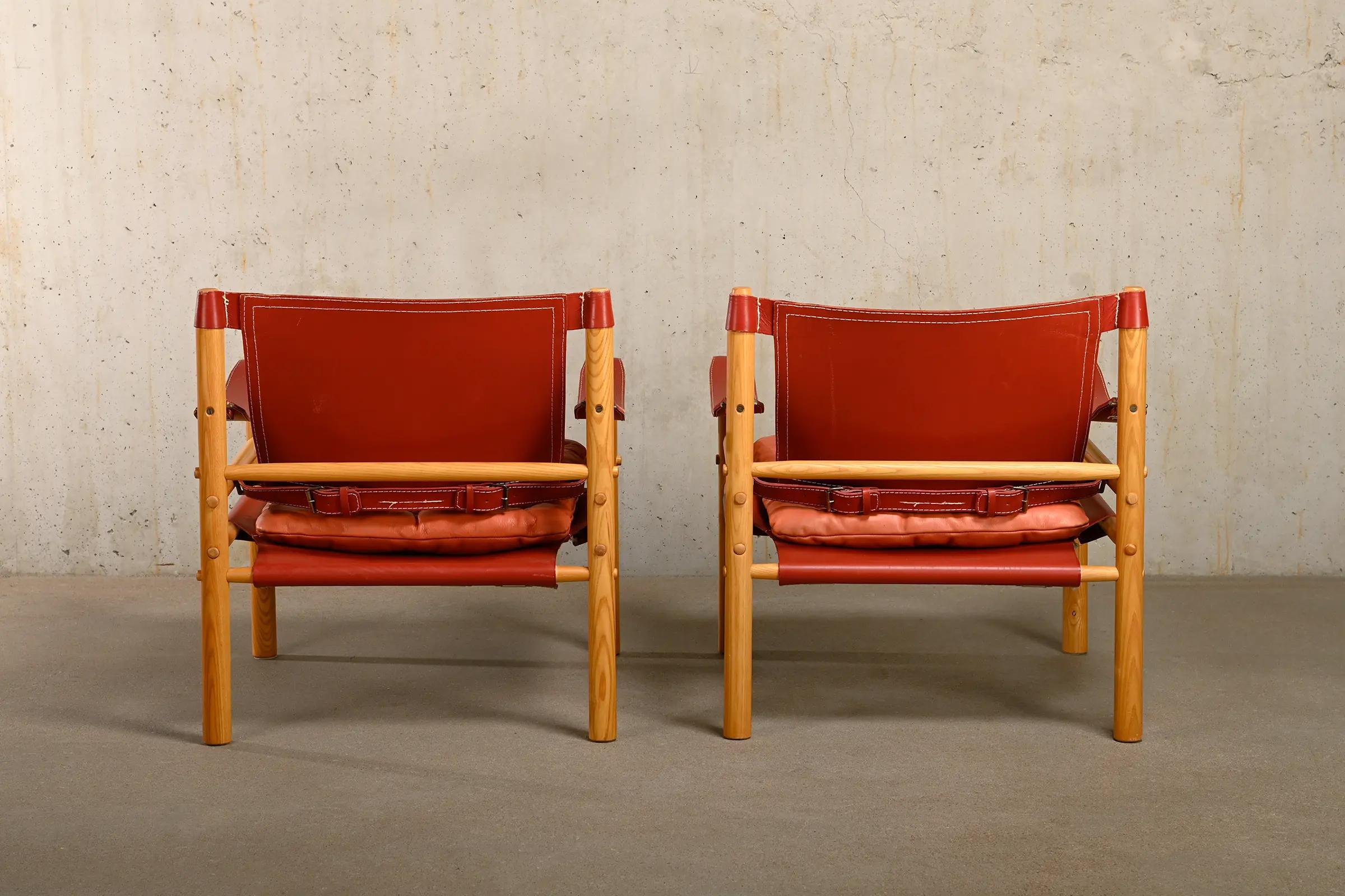 Arne Norell Paar Sirocco Safari-Loungesessel aus rotem Leder und Esche, Schweden (Mitte des 20. Jahrhunderts)