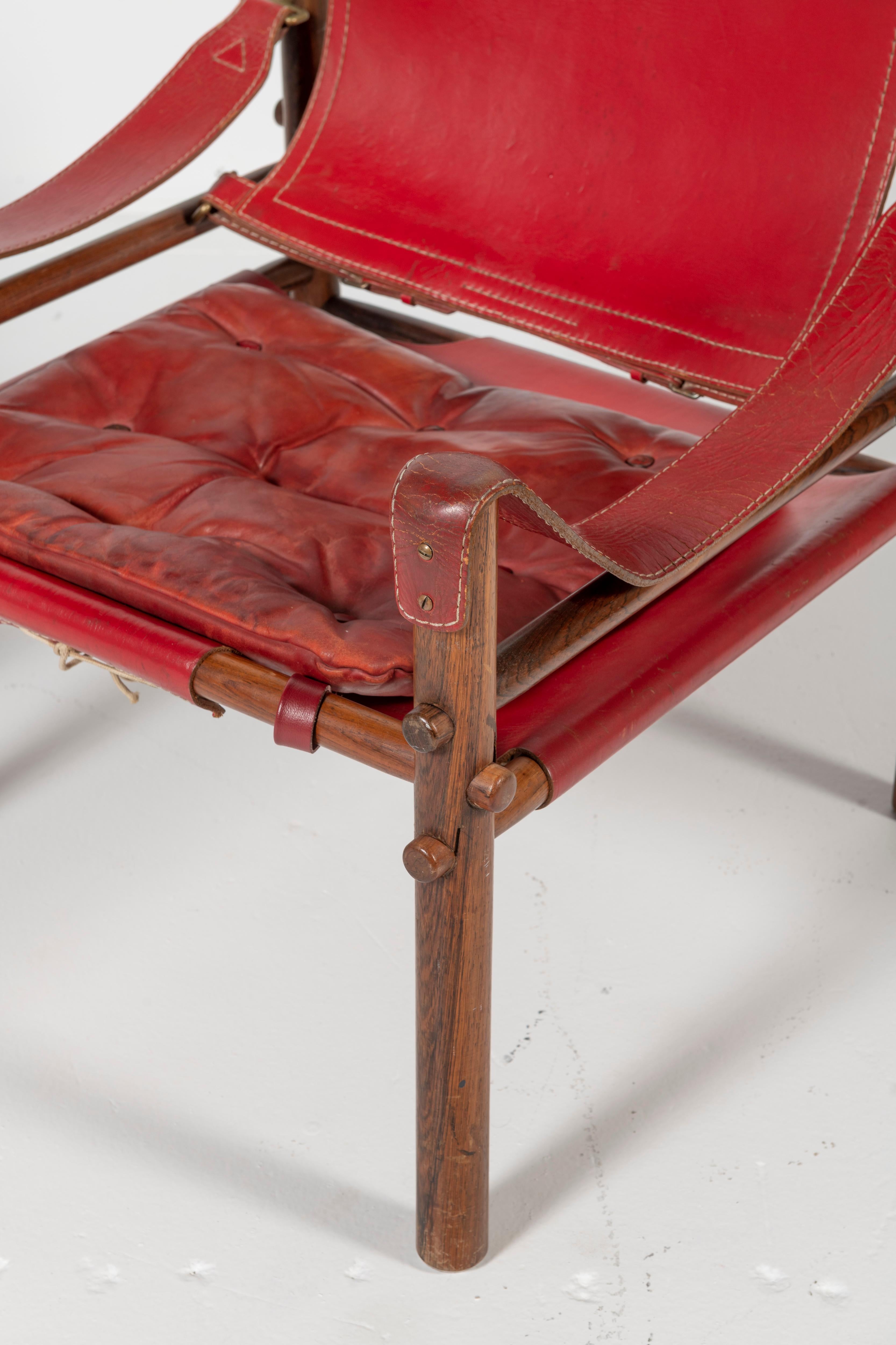 Pair of safari chairs, Sirocco model in good condition with original red leather.
Designed by Arne Norell, produced by Arne Norell AB in Aneby, Sweden, 1960s.