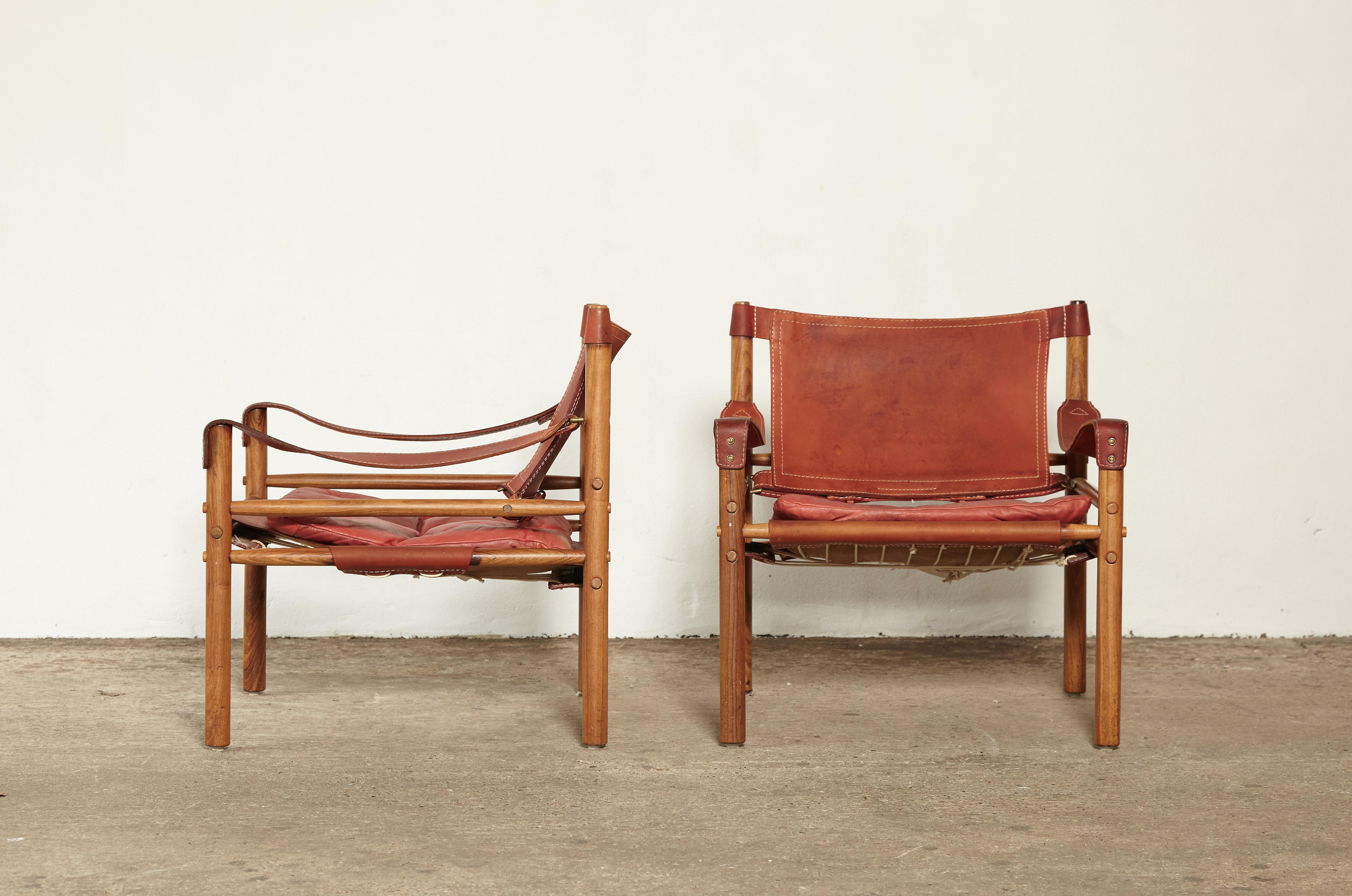 A super pair of authentic vintage Arne Norell safari sirocco chair in rosewood and rare red leather. Good vintage condition with some fading to frames and marks to leather. Made by Norell Mobler in Sweden.

Ships worldwide. The chairs will need to