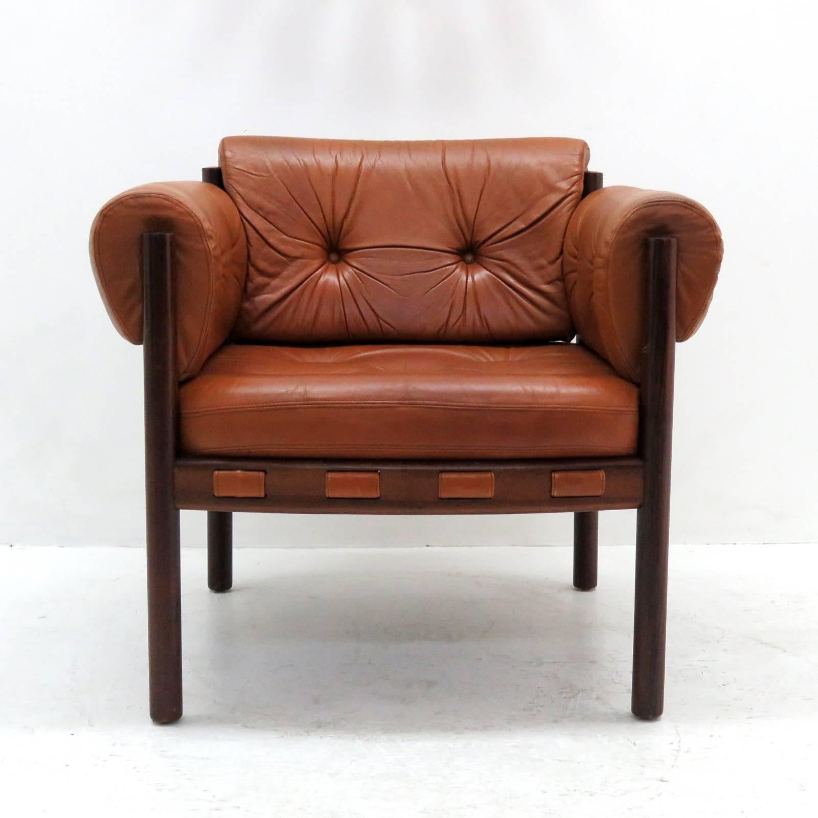Stunning pair of leather and rosewood armchairs designed in the early 1960s by Arne Norell for Coja Culemborg, with thick tufted cognac colored leather on a sturdy, solid rosewood frame. The chairs are as comfortable as they look.