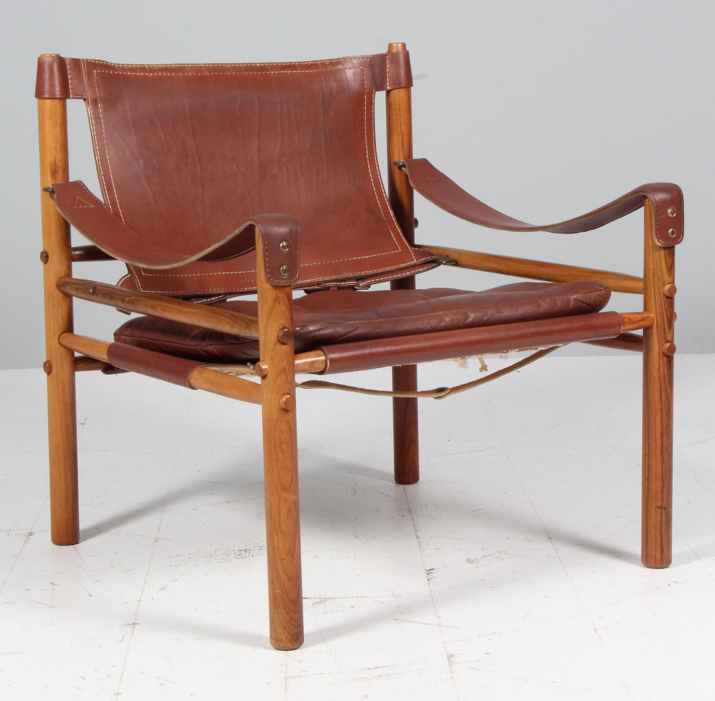 Silla safari Arne Norell. Cojines originales tapizados de espuma con cuero patinado.

Marco de madera de palisandro.

Modelo Scirocco, fabricado por Norell.