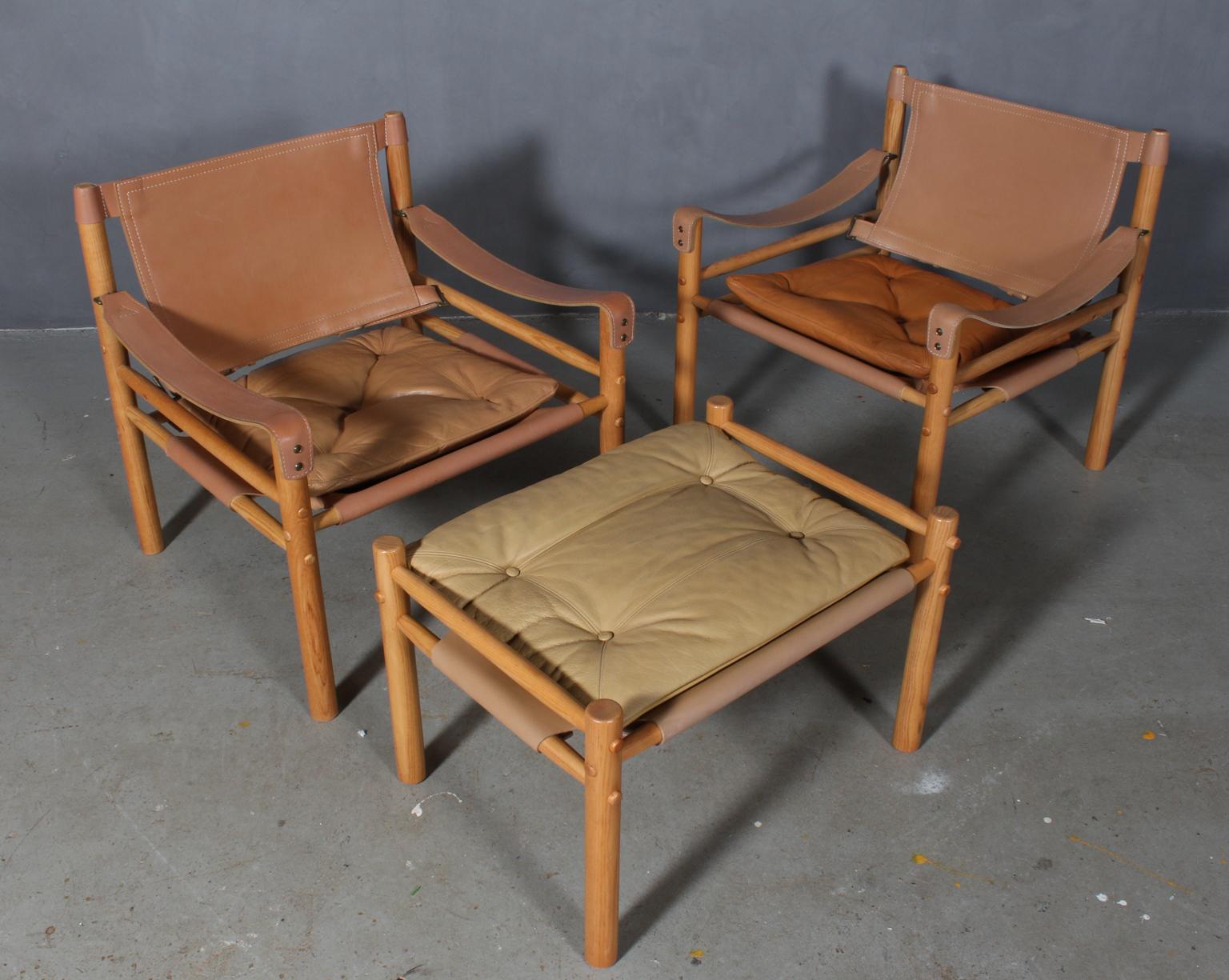 Set of Arne Norell safari chairs with ottoman. Original upholstered foam cushions with patinated leather.

Frame of ash.

Model Scirocco, made by Norell.
