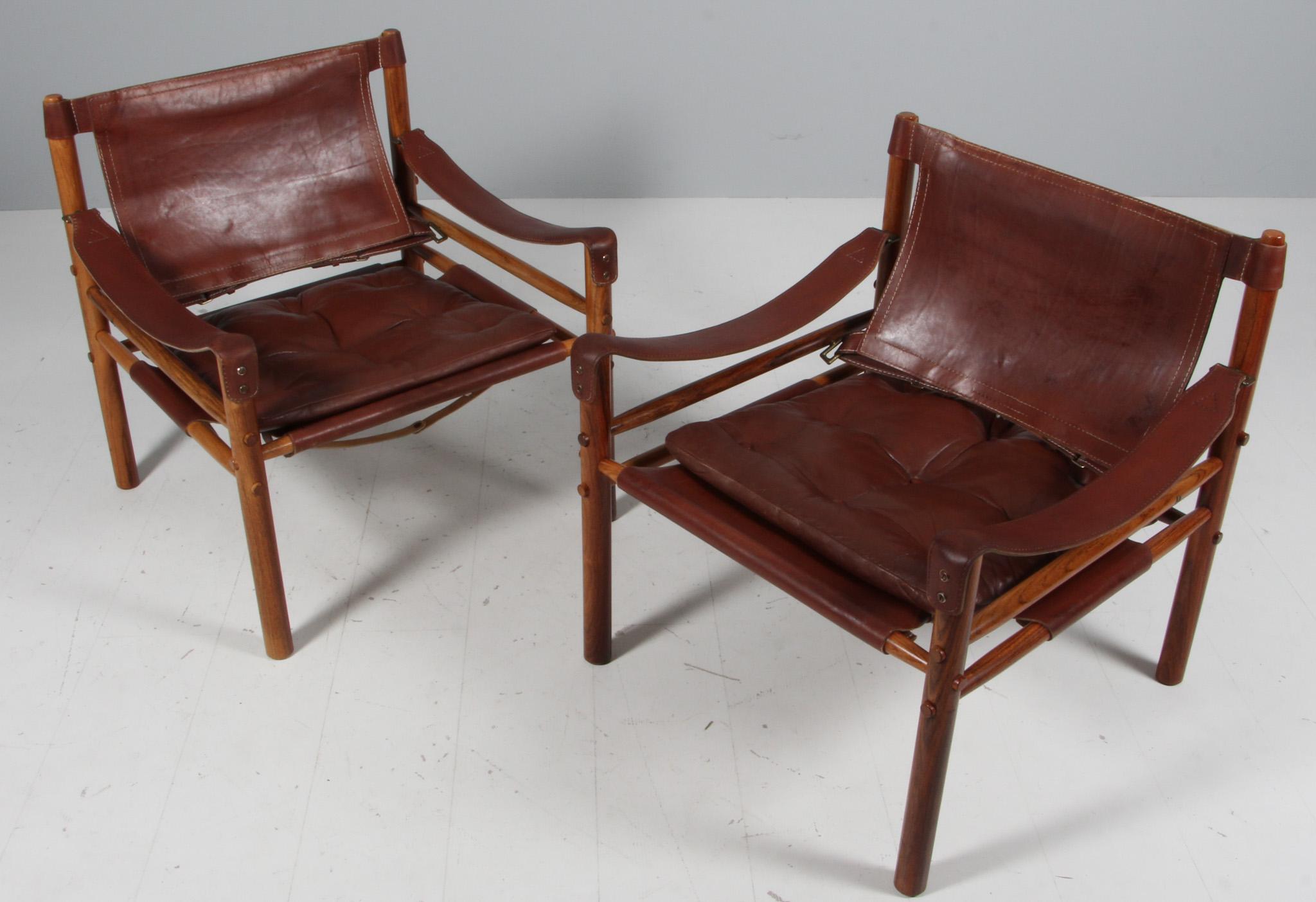 Set of Arne Norell safari chairs. Original upholstered foam cushions with patinated leather.

Frame of rosewood.

Model Scirocco, made by Norell.
