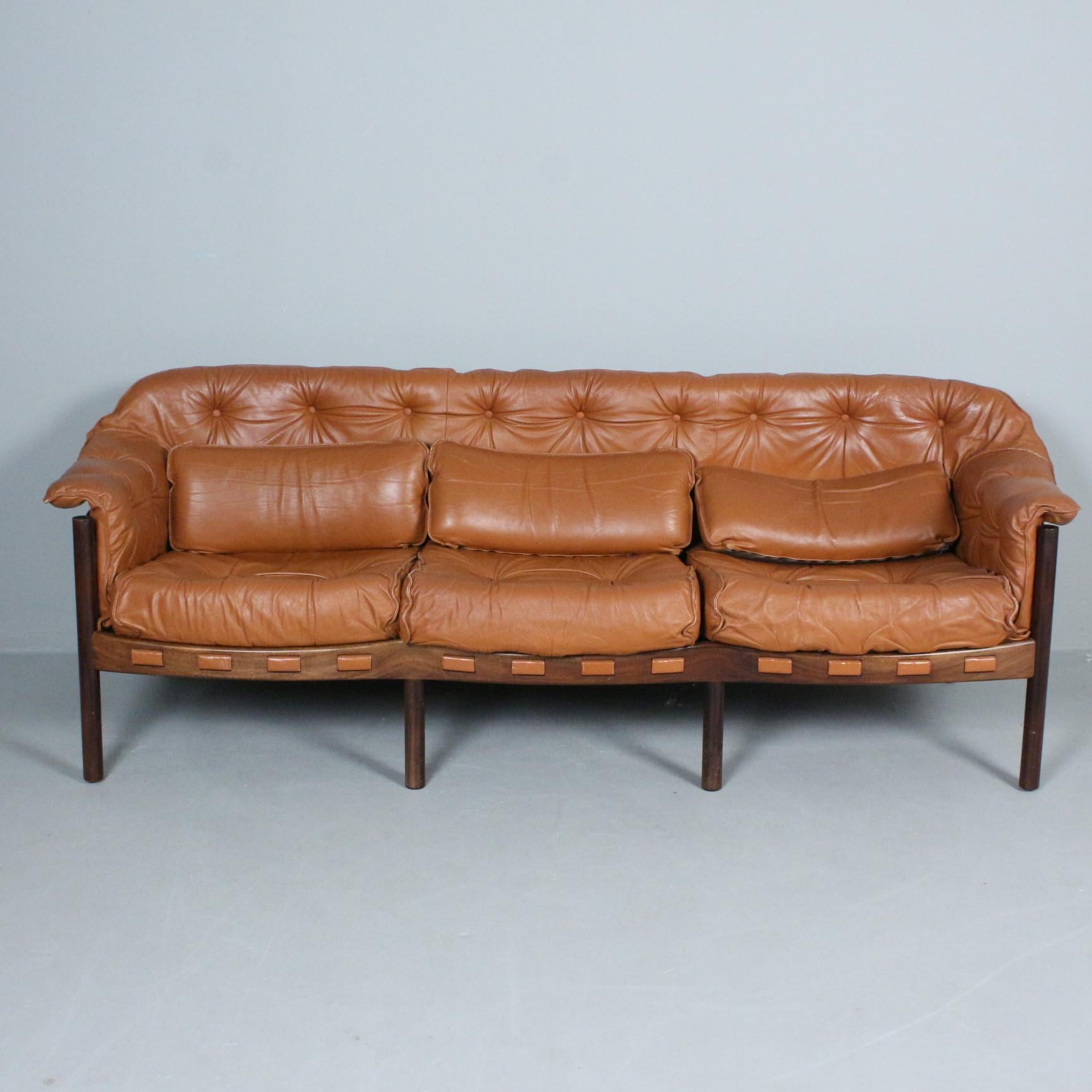Arne Norells Set aus einem 3-sitzigen Sofa und dem passenden Sessel aus braunem Leder und Teakholz für Coja, hergestellt in Schweden um 1960
Guter Gesamtzustand: Holzstruktur in gutem Zustand, einige Abnutzungserscheinungen auf dem hellbraunen
