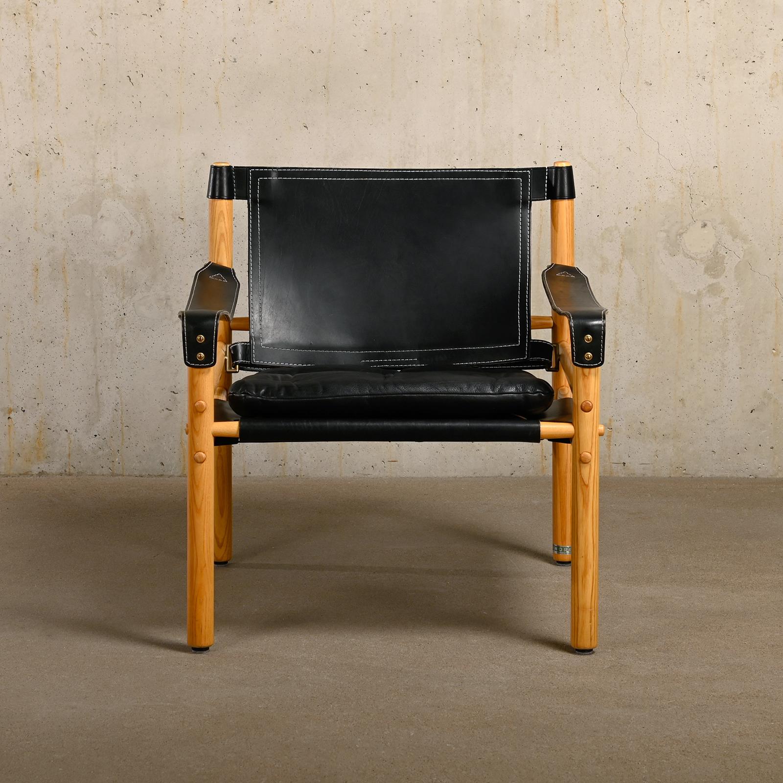 Superbe chaise longue Sirocco Safari, conçue par Arne Norell et fabriquée par Norell Möbel AB en Suède. Cadre en frêne légèrement patiné avec le coussin d'origine en cuir noir. Tous en très bon état. Signé avec l'étiquette du fabricant.