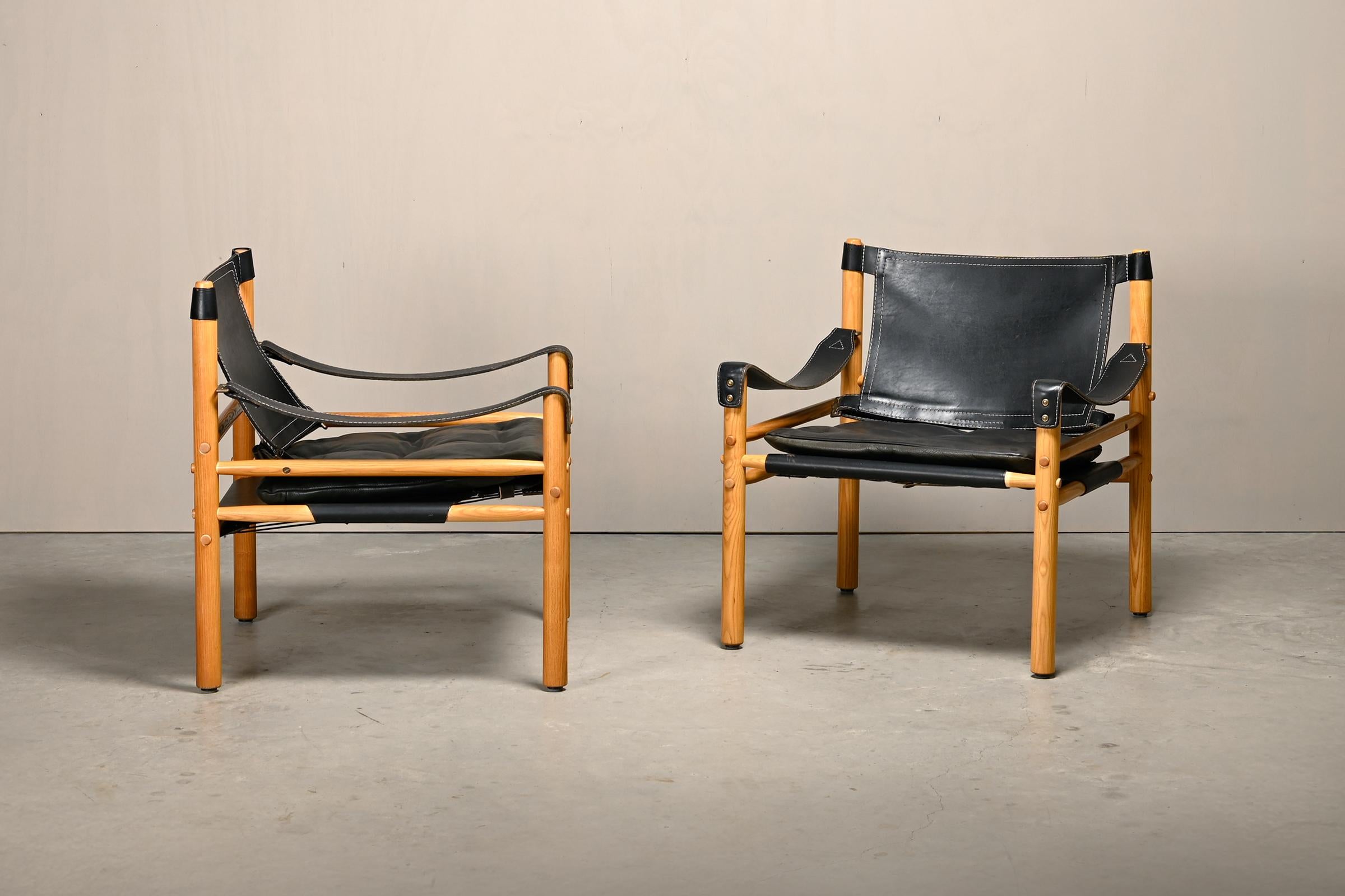 Pareja de tumbonas Sirocco Safari diseñadas por Arne Norell y fabricadas por Norell Möbel AB en Suecia, años setenta. Armazones de madera maciza de fresno con los cojines originales de precioso cuero negro patinado. Todo en muy buen estado vintage,