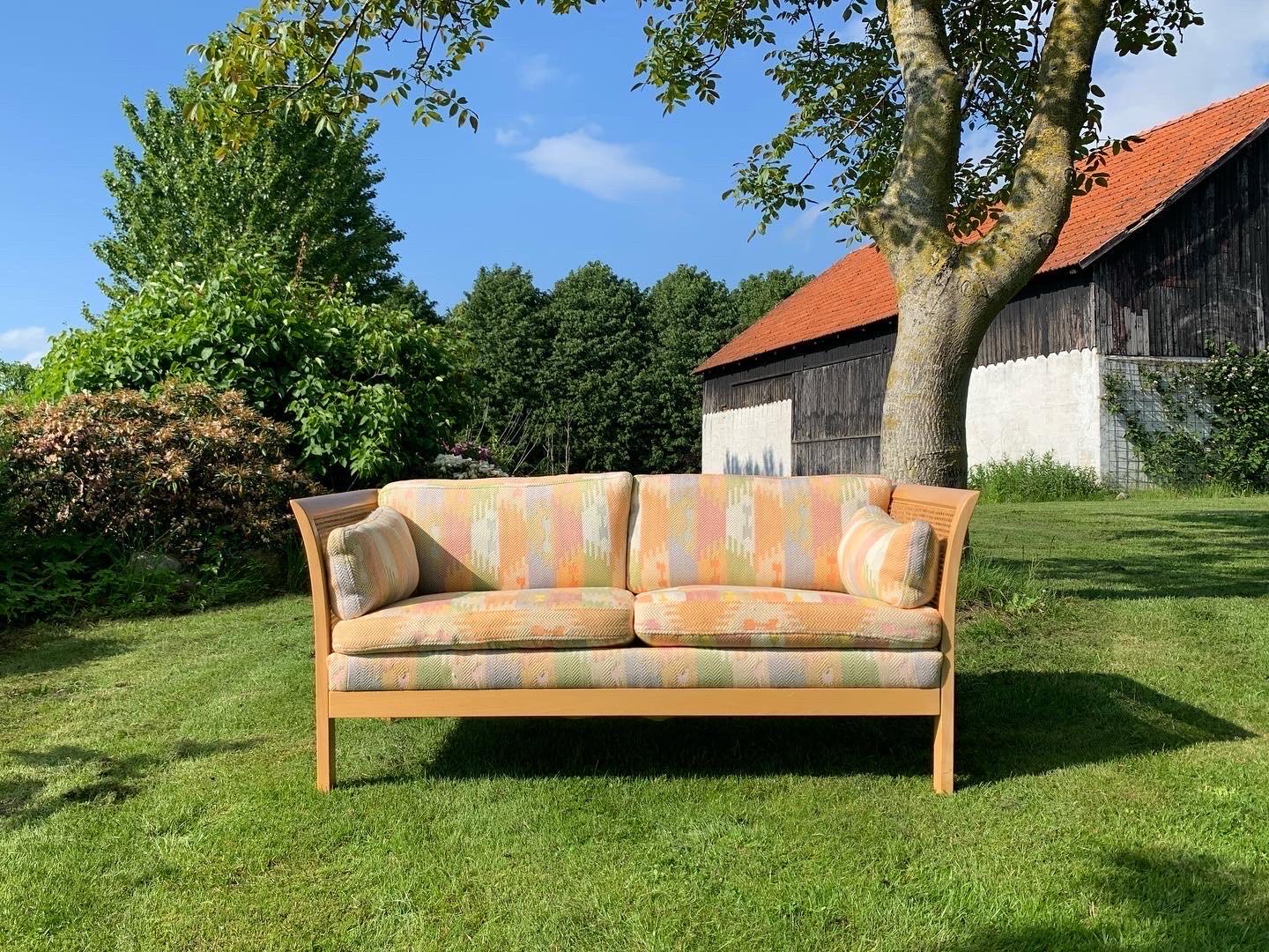 Vintage sofa in light wood, caning and upholstered with the original cool fabric from the 1980s. The sofa is in good condition.

A well-designed sofa by talented Swedish designer Arne Norell (1917-1971). The designer created a piece that radiates