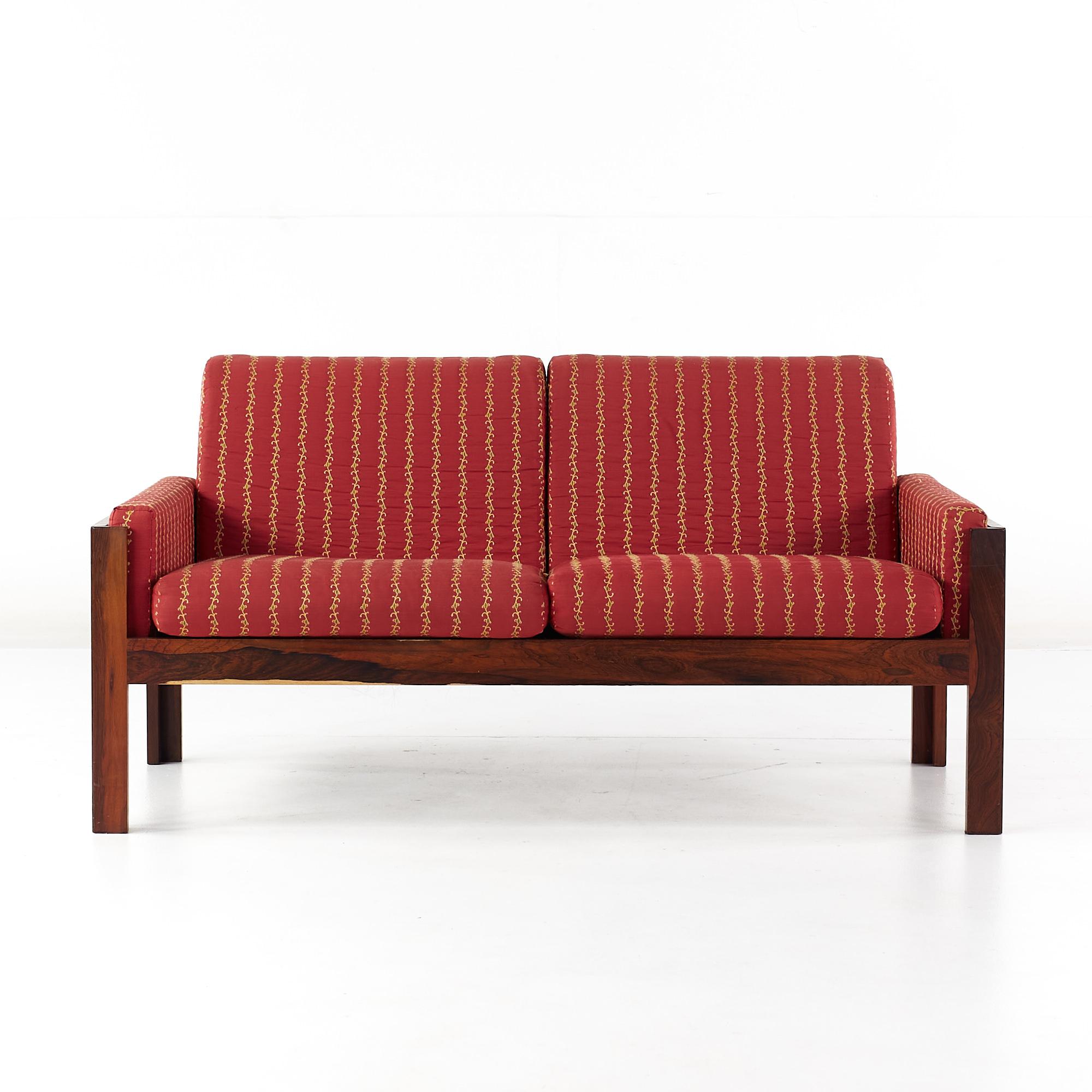 Canapé en bois de rose danois de style Arne Norell, datant du milieu du siècle dernier.

Ce canapé mesure : 51.25 de large x 27 de profond x 26 de haut.

Tous les meubles peuvent être obtenus dans ce que nous appelons un état vintage restauré.