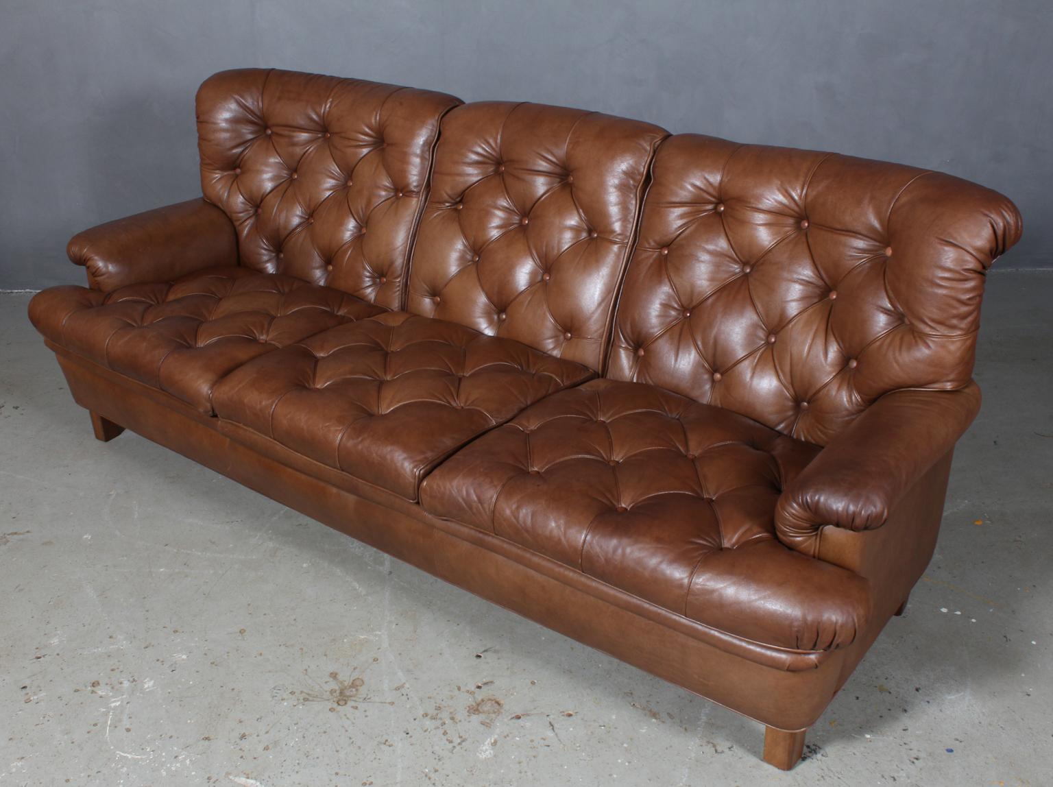 Arne Norell three-seat sofa with legs of stained beech

Original brown leather upholstery.

Made by Norell.