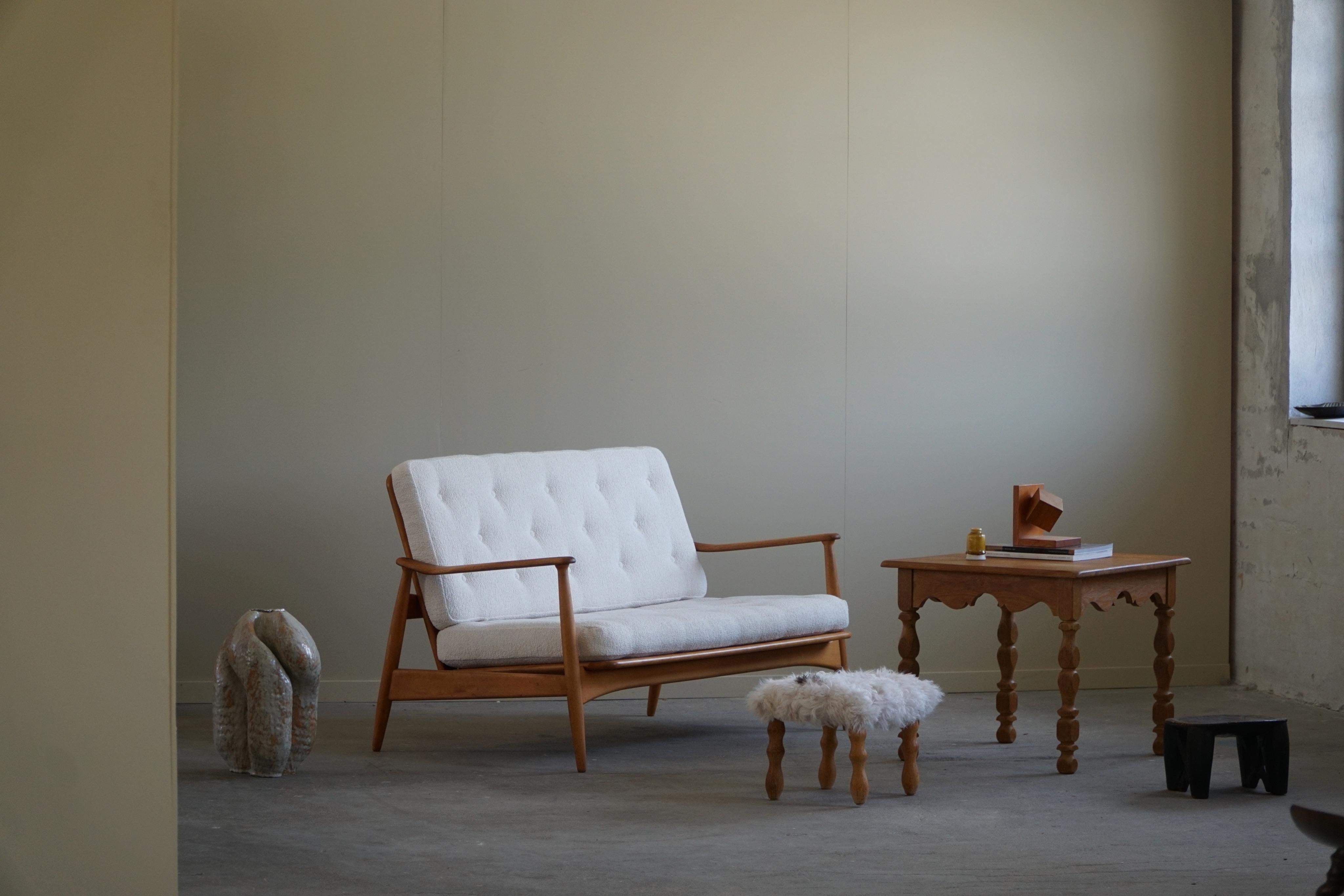 Ein schönes Beispiel für ein modernes dänisches 2-Sitzer-Sofa aus massiver Buche, mit neu gepolsterten Kissen aus weißem Bouclé. Entworfen von Arne Vodder für France & Daverkosen in den 1950er Jahren, Dänemark. 
Ein klassisches Design, das viele