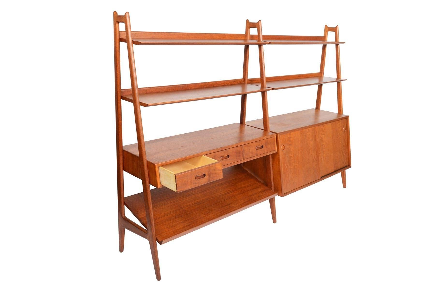 This Danish modern freestanding bookcase in teak was the product of a collaboration between Arne Vodder and Anton Borg for Vamo Sønderborg in the 1950s. This two bay design stands on three, beautifully joined a- frames. Four shelves with lipped