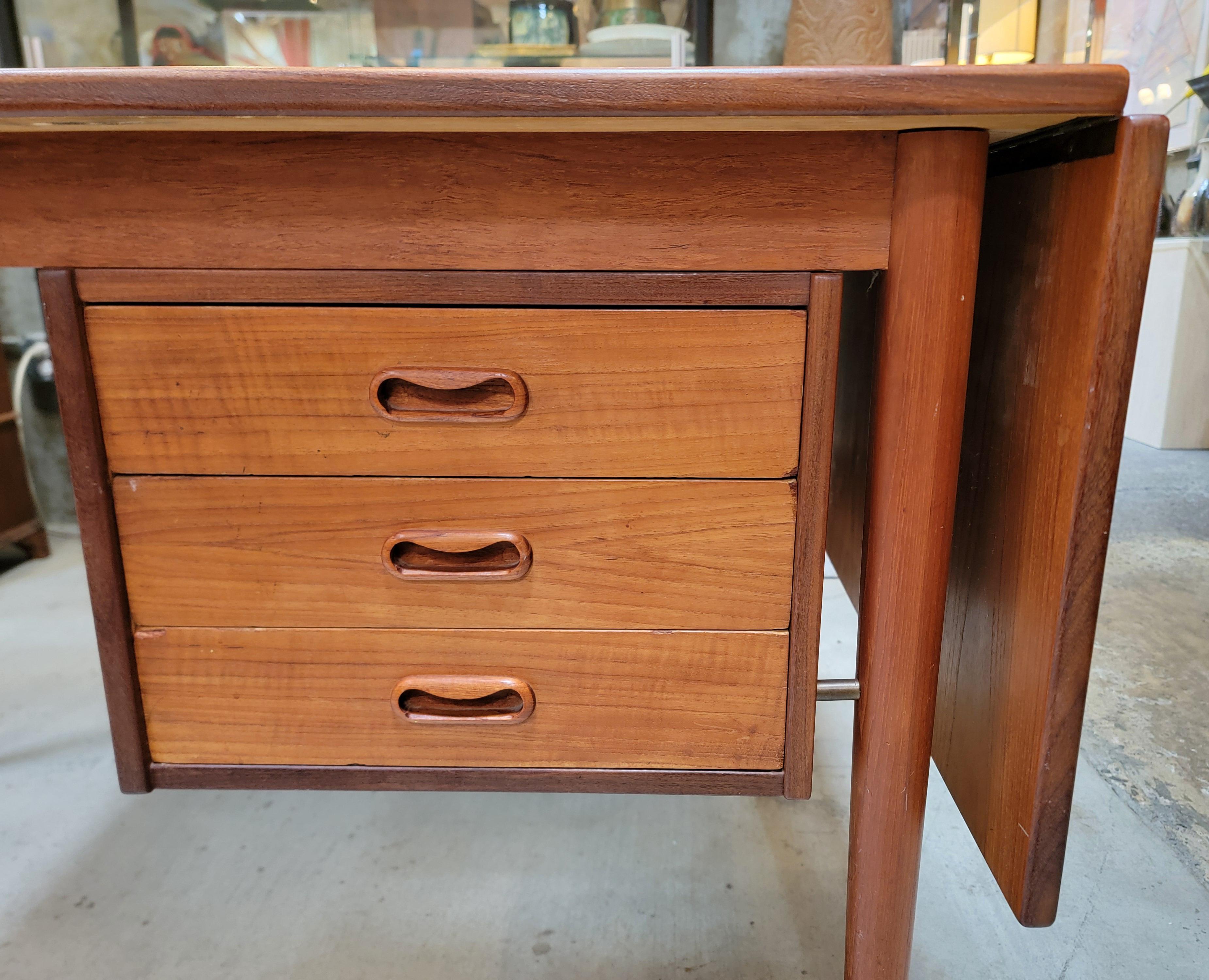Fine teak Danish Modern expanding desk attributed to Arne Vodder. Denmark, circa. 1960's. Finished on all 4 sides with 3 graduated drawers and additional storage on back side. Side of desk lifts and slides to expand desk surface from 48.13 inches