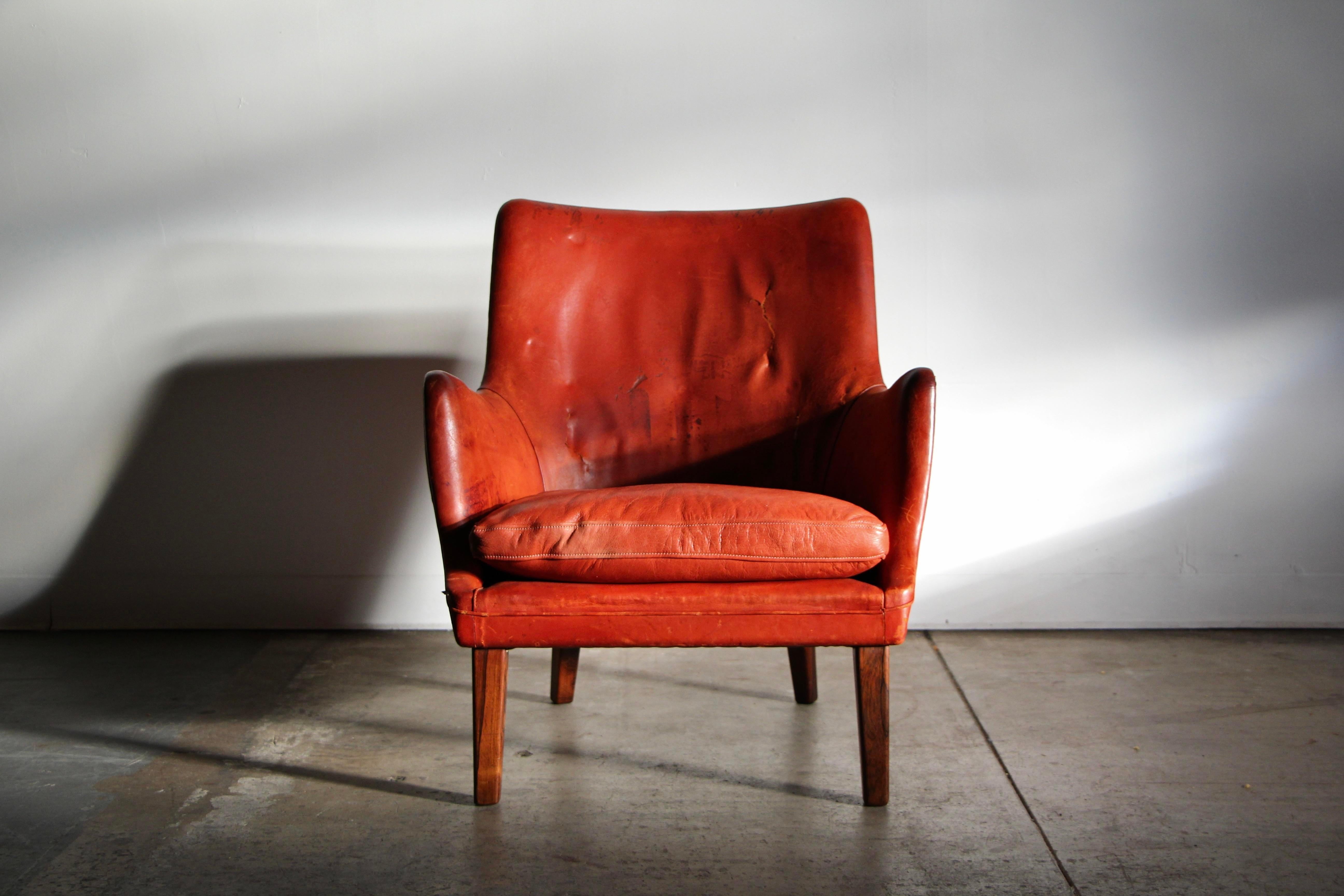 Chaise longue aux proportions magnifiques d'Arne Vodder, fabriquée par Ivan Schlechter au début des années 1950. Cet exemplaire arbore son cuir cognac d'origine, usé et ardent, et présente beaucoup de caractère. Quelques déchirures au niveau du
