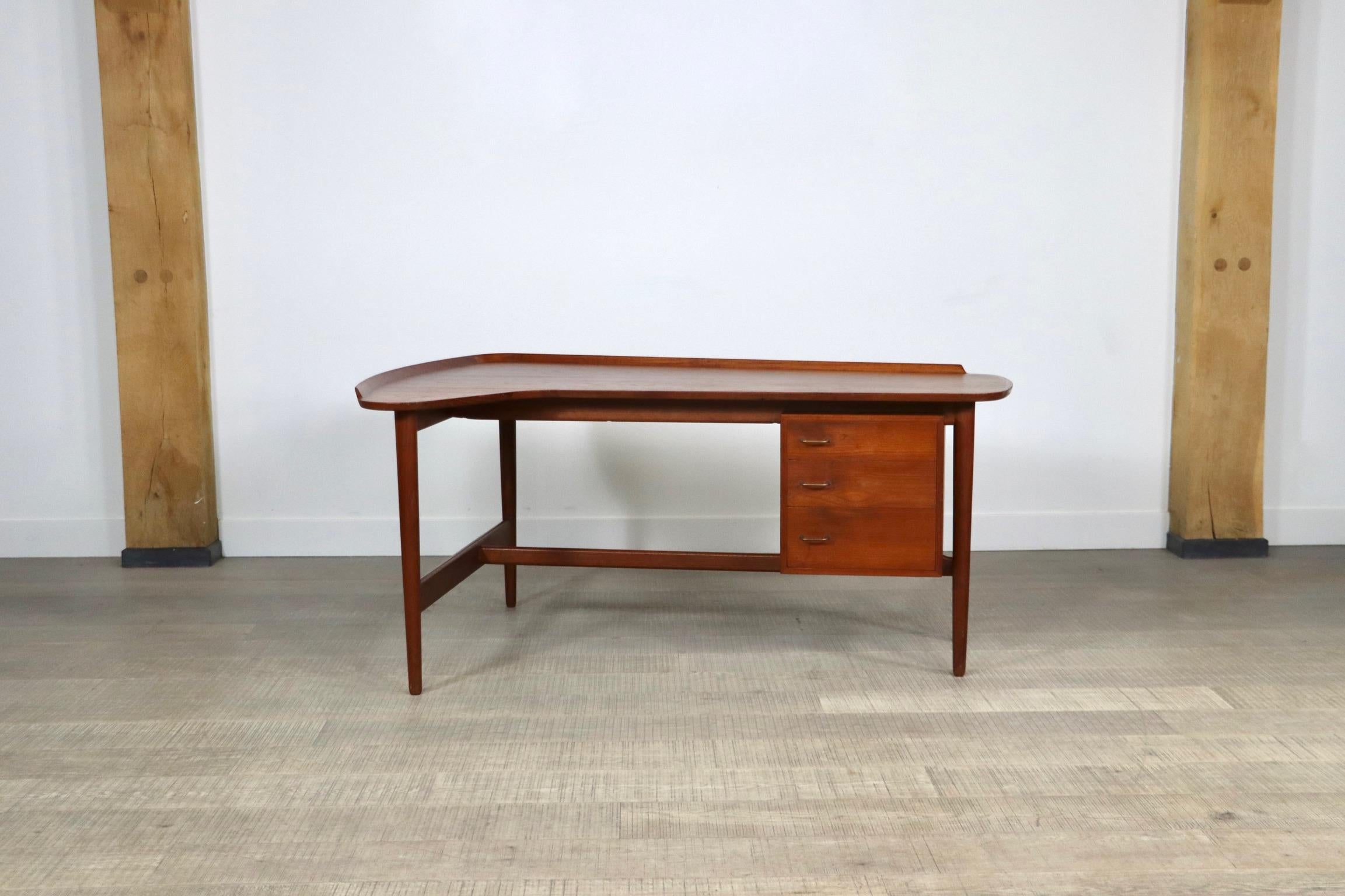 Rare Boomerang desk ’Model BO85’ in teak with brass handles. This desk was designed by Arne Vodder for Bovirke. The desk has an organically shaped table top with raised edges. The handcrafted details are beautiful! On the right side it has a drawer