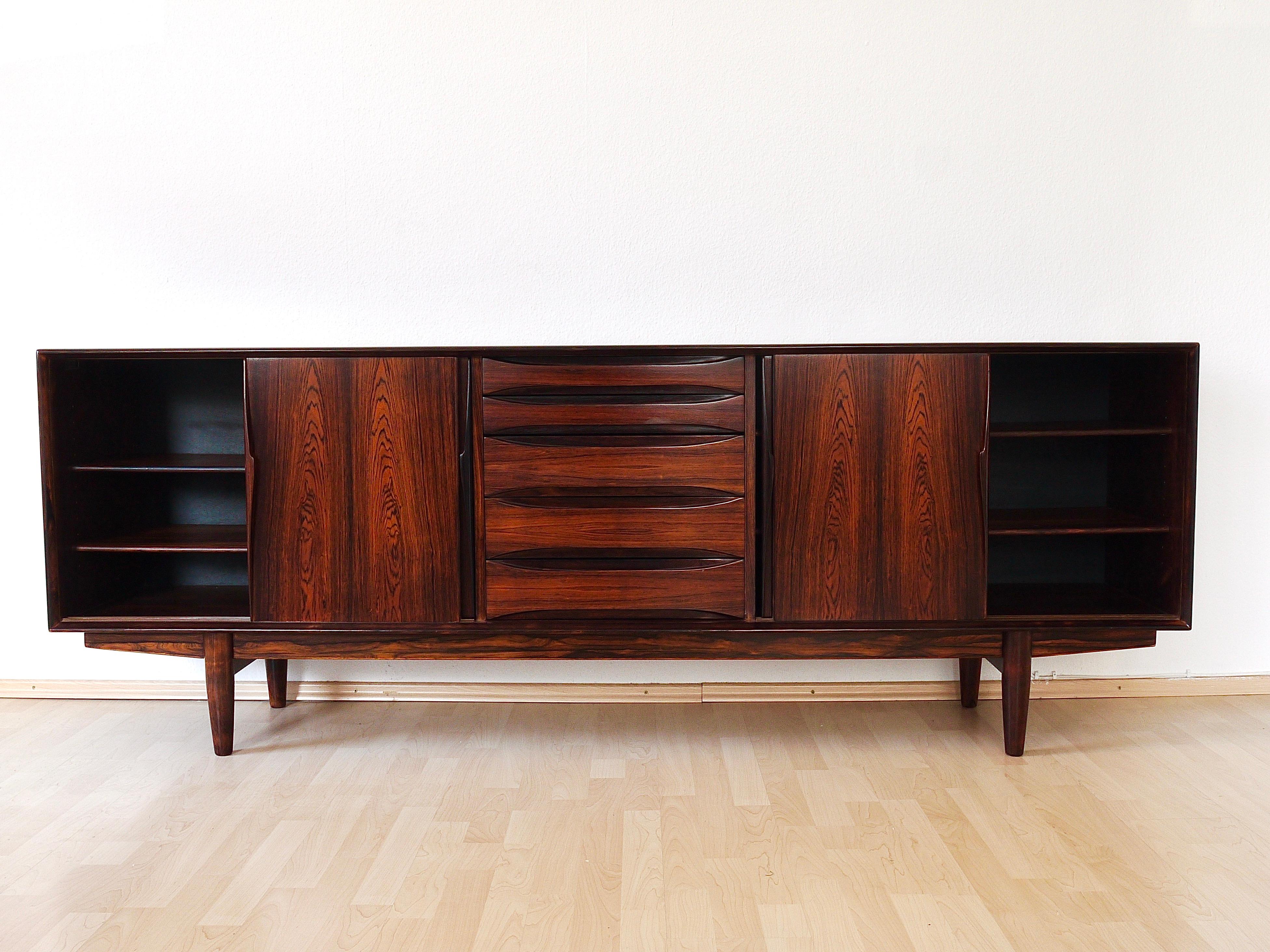 A beautiful midcentury sideboard, model 7738, designed by Arne Vodder, executed by Skovby Møbelfabrik in the 1960s. Top quality Danish craftsmanship, made of rosewood with amazing grain. This piece of furniture offers four sliding doors, with