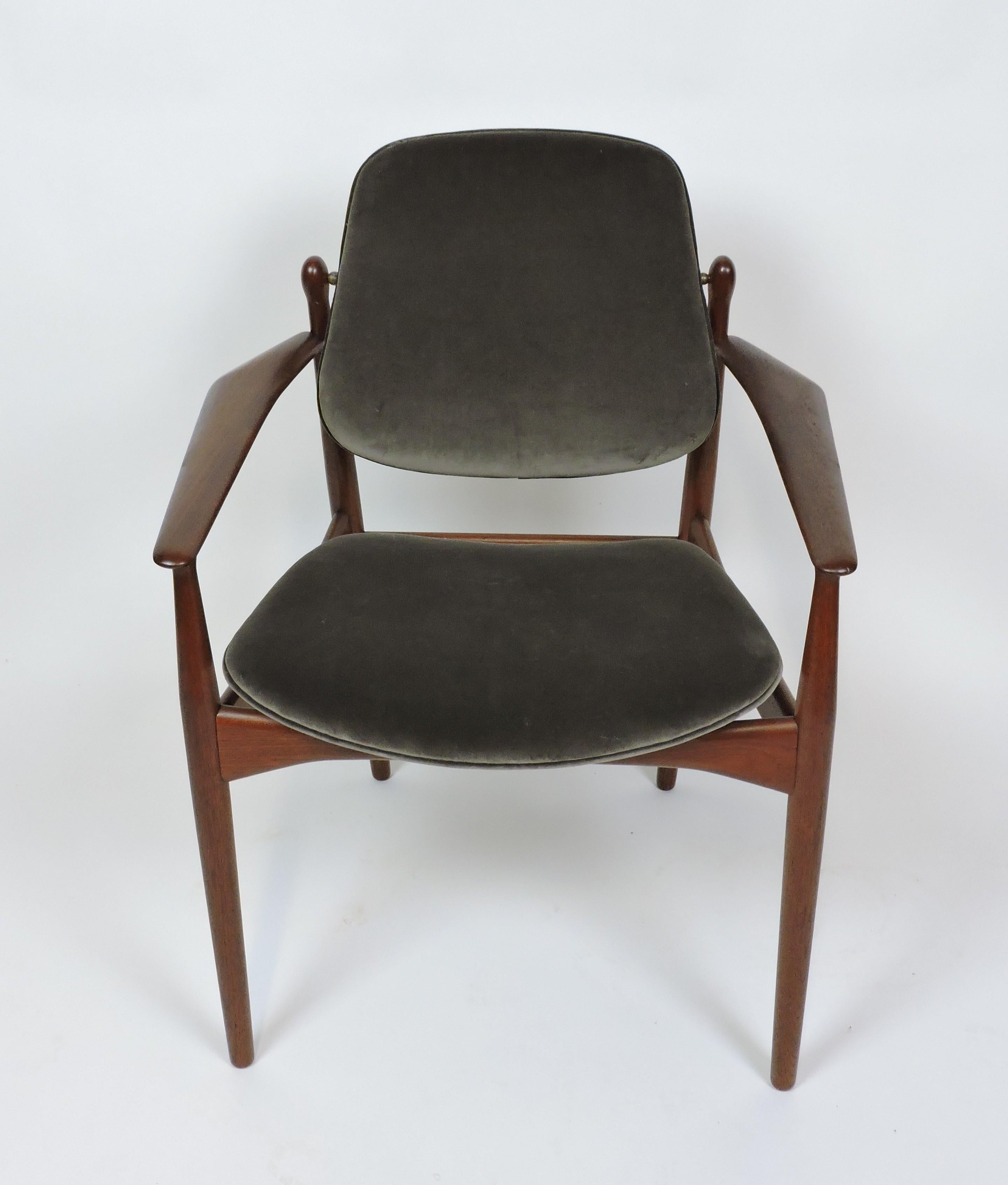 Danish modern teak arm chair, model FD 184/L, designed by Arne Vodder in 1956 and made in Denmark by France and Daverkosen. This elegant chair has a floating seat, a back that pivots on brass fittings for comfort, and a solid teak sculptural frame.