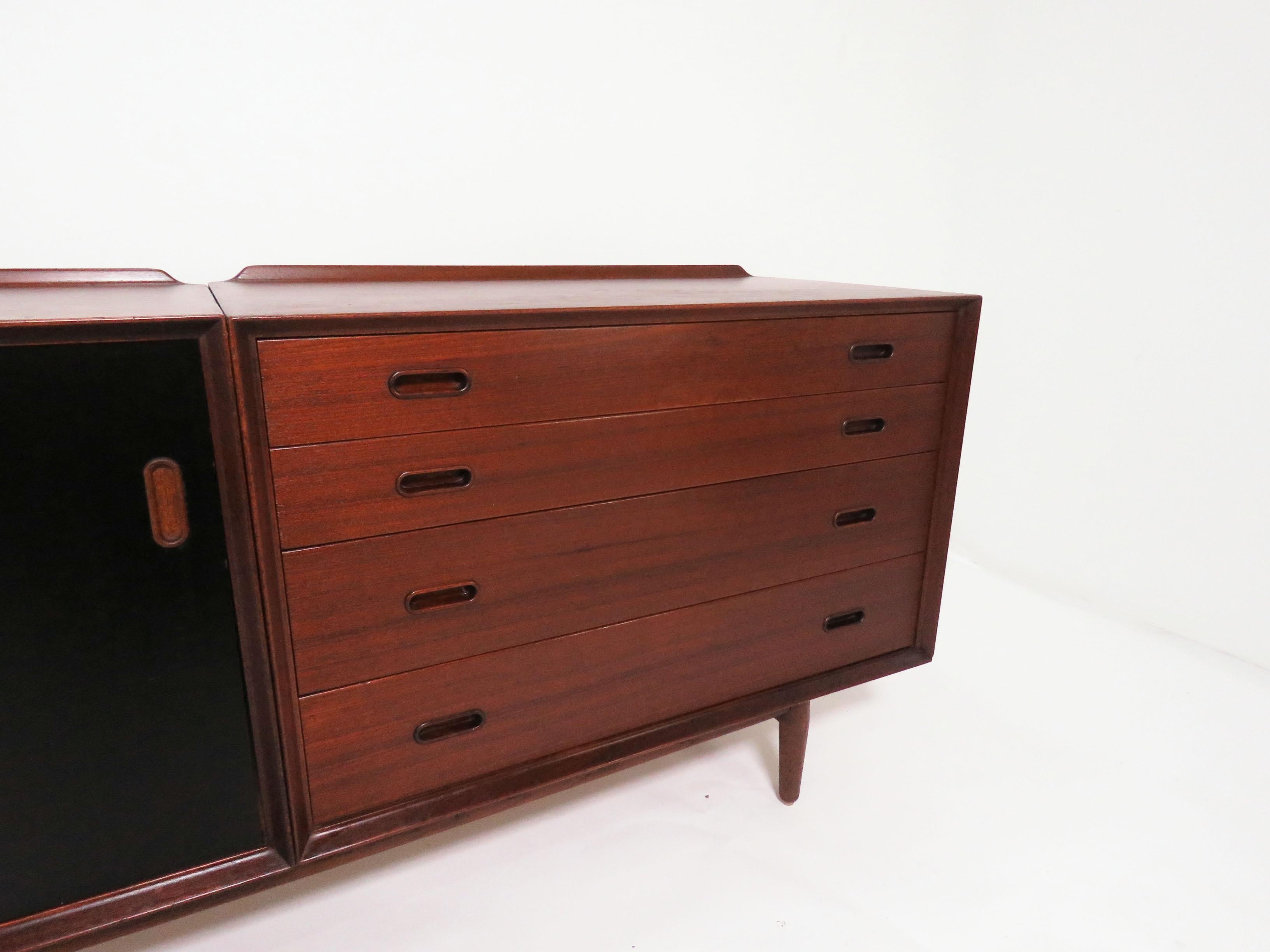 Danish teak credenza designed by Arne Vodder, made by Sibast, Denmark, circa 1960s. The black lacquered doors are reversible to teak fronts. Further, as this consists of two cabinets (a unit of drawers and a sliding door unit) that mount onto the