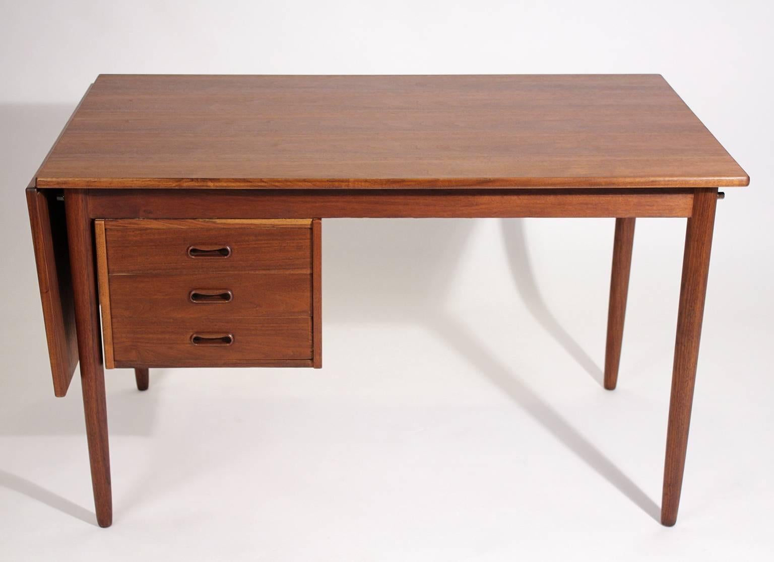 Beautiful teak wood Danish drop-leaf expandable desk designed by Arne Vodder. The desk has a drop leaf that can be used for more room. Drawers can be moved from side to side so you can move your chair to either side. Great design. Desk has wonderful
