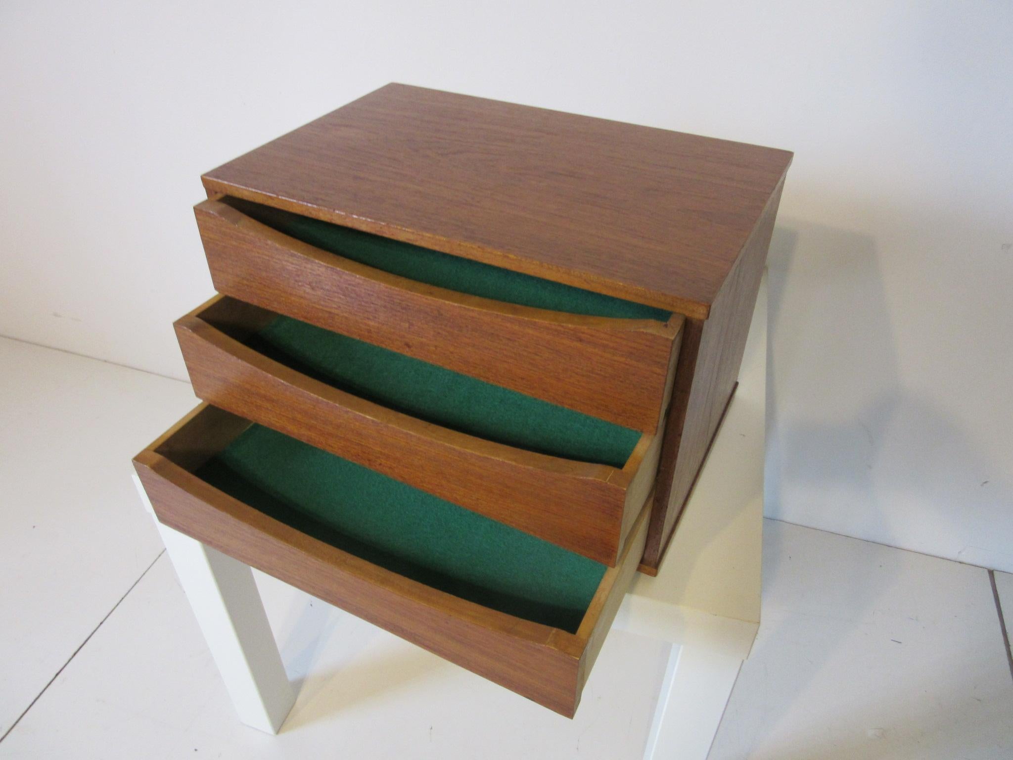 A simple three-drawer teak wood jewelry or watch box / chest with Vodder's signature cut away designed arched drawer pulls, lined in felt and ready for your precious jewelry or watches, made in Denmark.
