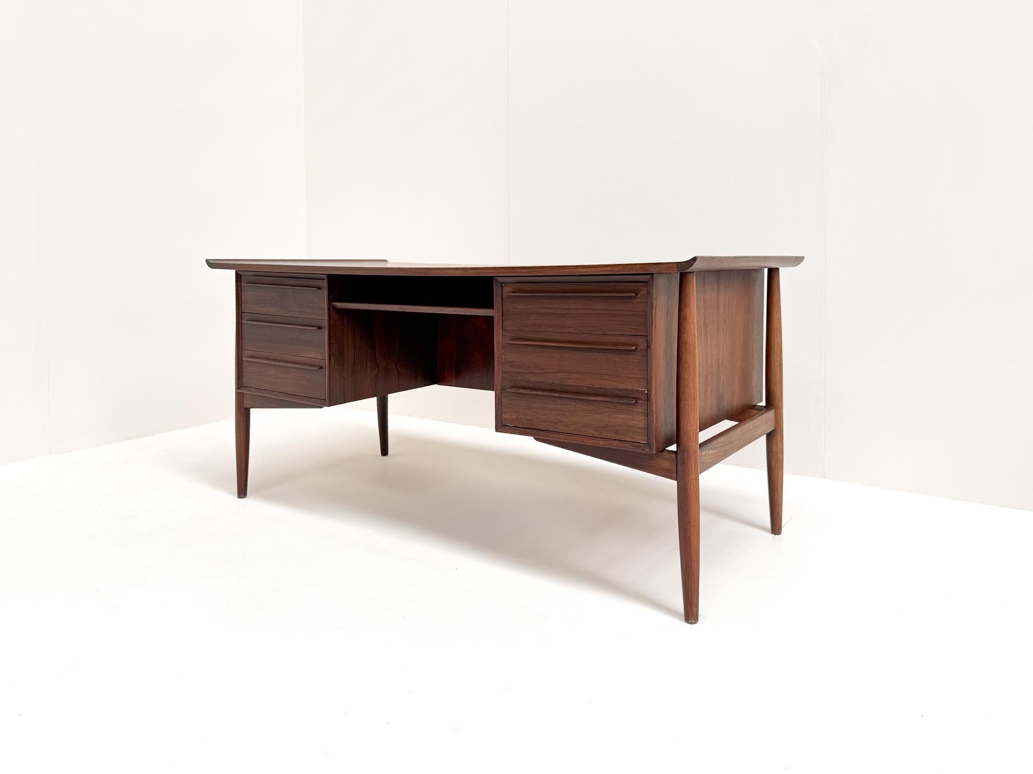 Este elegante escritorio independiente fue diseñado por Arne Vodder para H.P. Hansen en Dinamarca en la década de 1960. De palisandro ricamente veteado, presenta un raro diseño simétrico con cajones a ambos lados y un respaldo totalmente acabado. La
