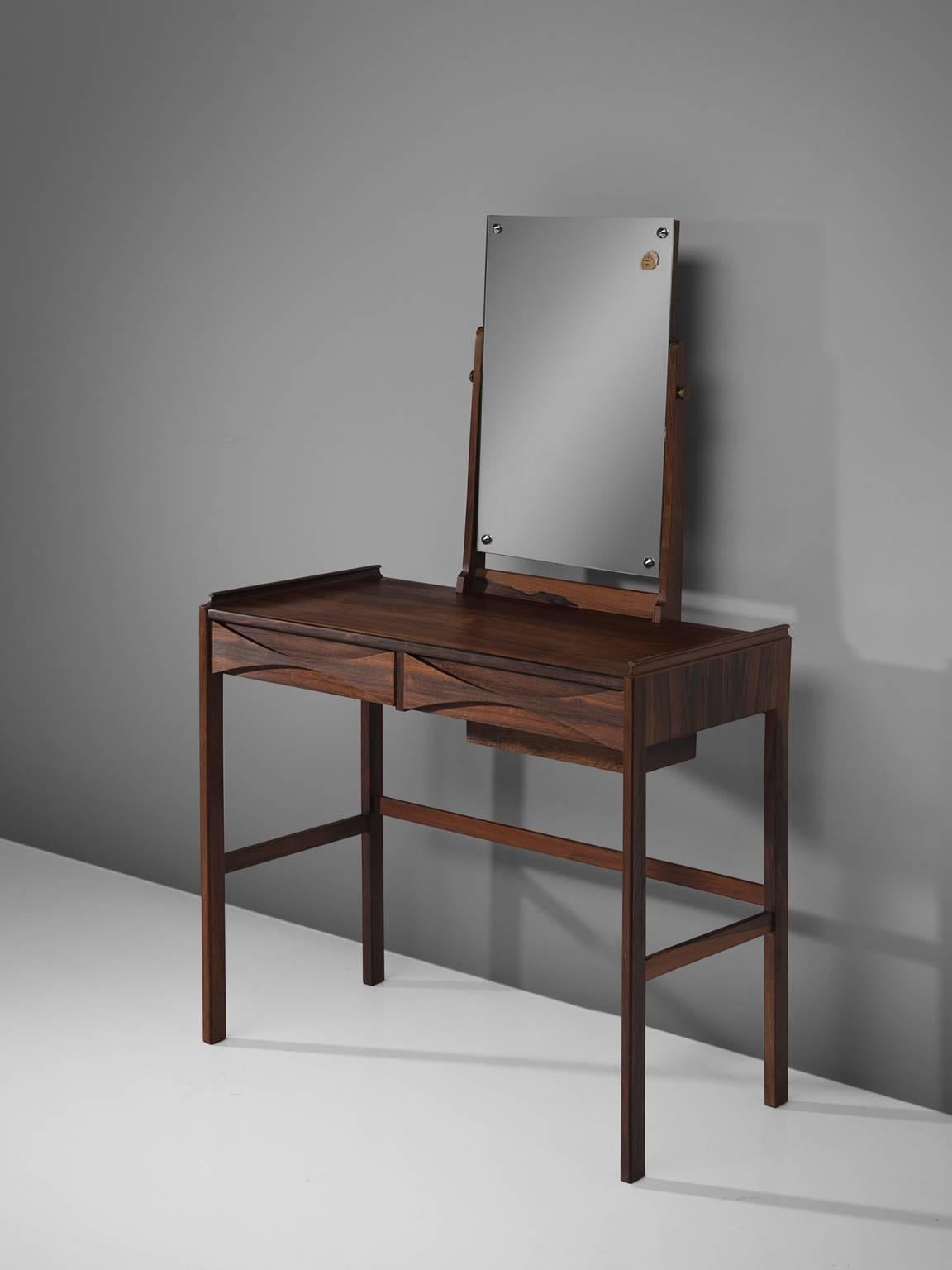 Arne Vodder, dressing table, rosewood, mirror, Denmark, 1950s.

This refined, delicate dressing table is designed by Arne Vodder. The piece features the quintessential bow tie grips that is Vodder's trademark. The piece holds several details that